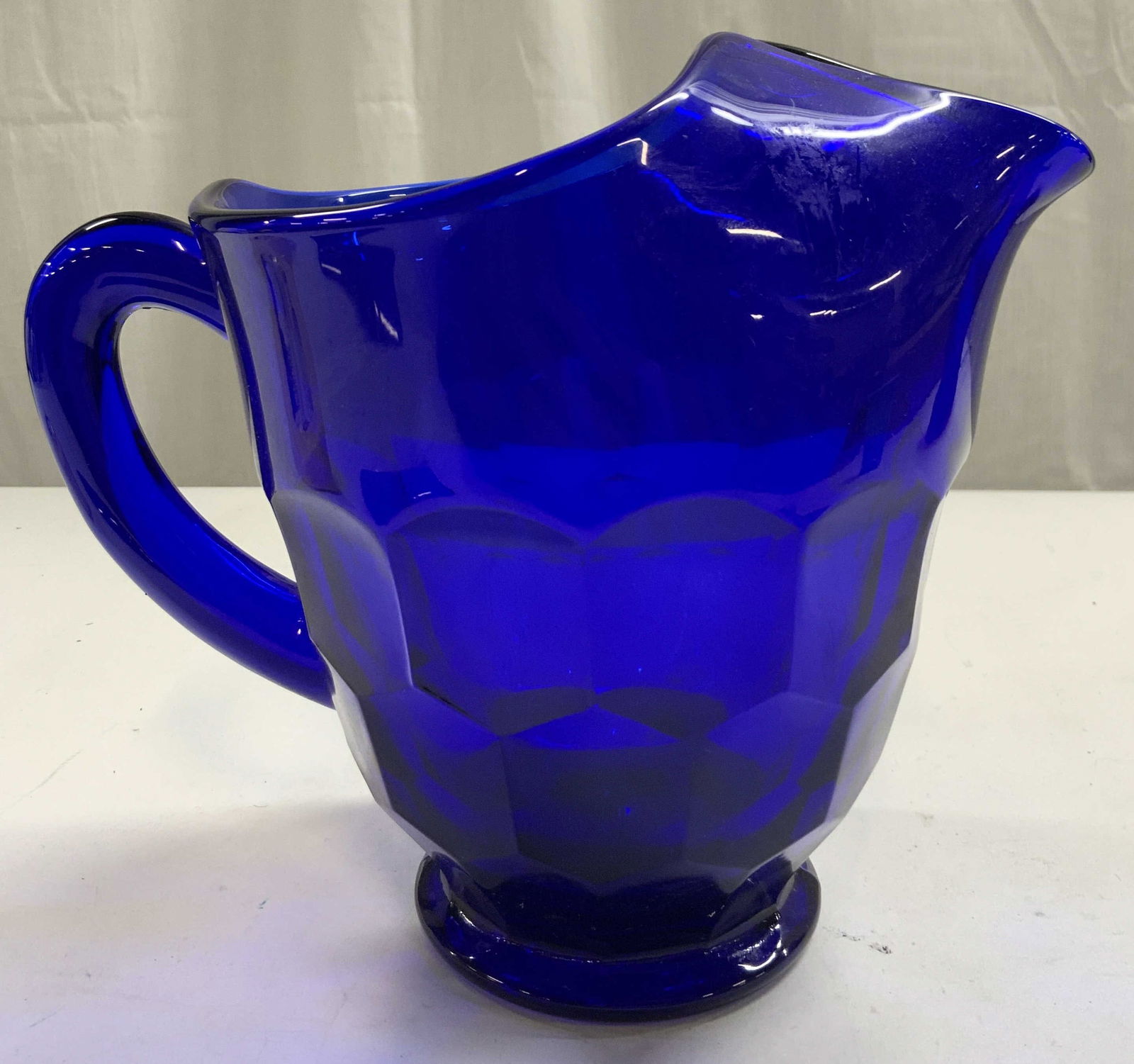 MOSSER Georgian Cobalt Art Glass Pitcher: Pitcher appears to be MOSSER, no apparent markings. Georgian Art glass pitcher. Pitcher is cobalt blue toned. Piece appears to be vintage. Pitcher is footed. Piece measures approximately 7.5 inches ta