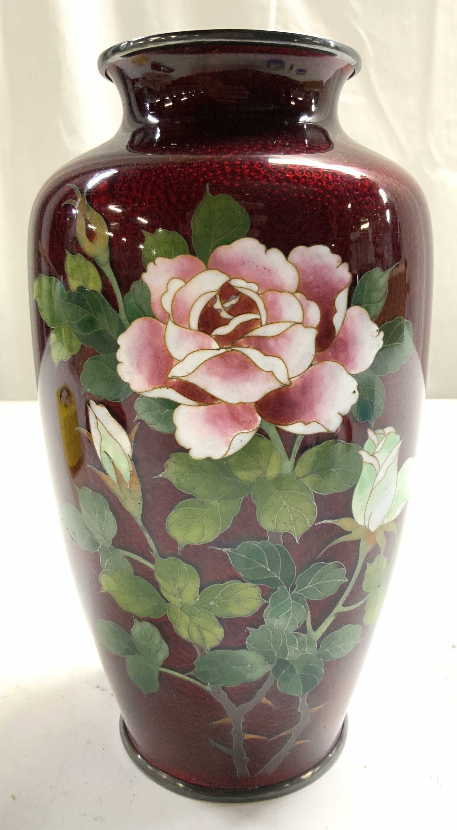 Vtg Asian Ginbari Cloisonne Blood Roses Vase 7in: Underside inscribed CPO. Vintage Japanese Ginbari Cloisonne Ando Sato Pigeon Blood Roses Vase. Piece is red with multi toned floral & leaf detail. Vase has metal rim. Piece measures approximately 7 in