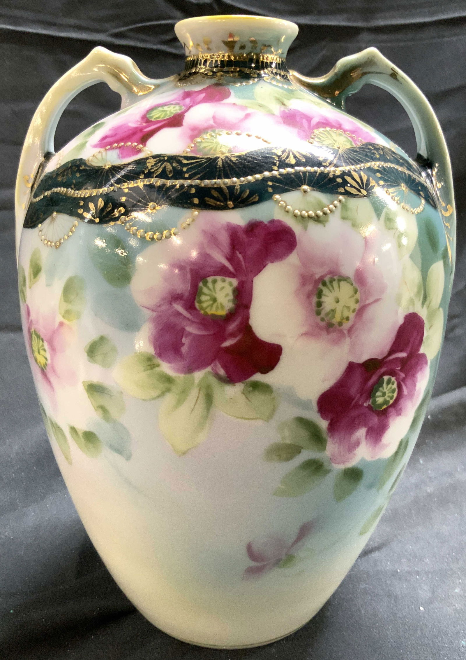 NIPPON Hand Painted Porcelain Vase W Handles: Underside is marked NIPPON HAND PAINTED. Vase is vintage and porcelain. Piece has multi toned floral and leaf detail. Vessel has handles at sides of top. Piece has narrow mouth. Vase measures approxim