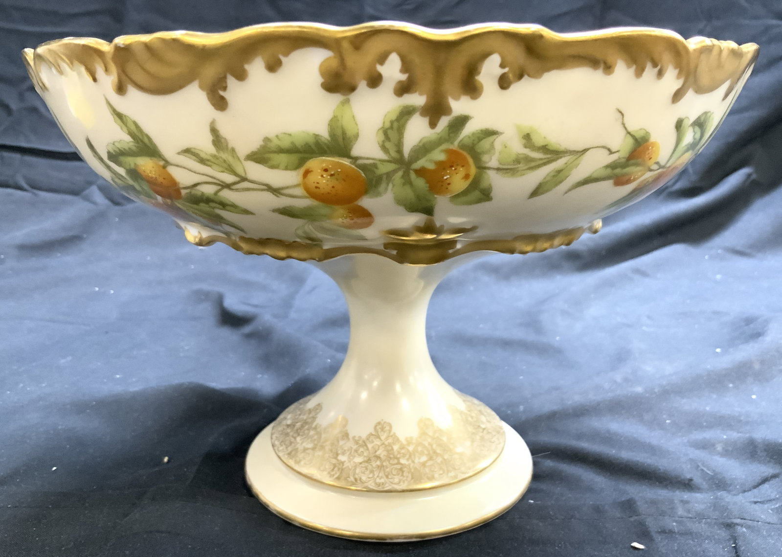 T&V FRANCE Ornate Porc Pedestaled Bowl: Underside is marked T&V FRANCE GREENLEAF & CROSBY CO. Bowl is pedestaled. Piece has fruit, vine and leaf detail. Vessel has intricate gilt scroll & leaf detail. Measures approximately 8.5 inches wide 