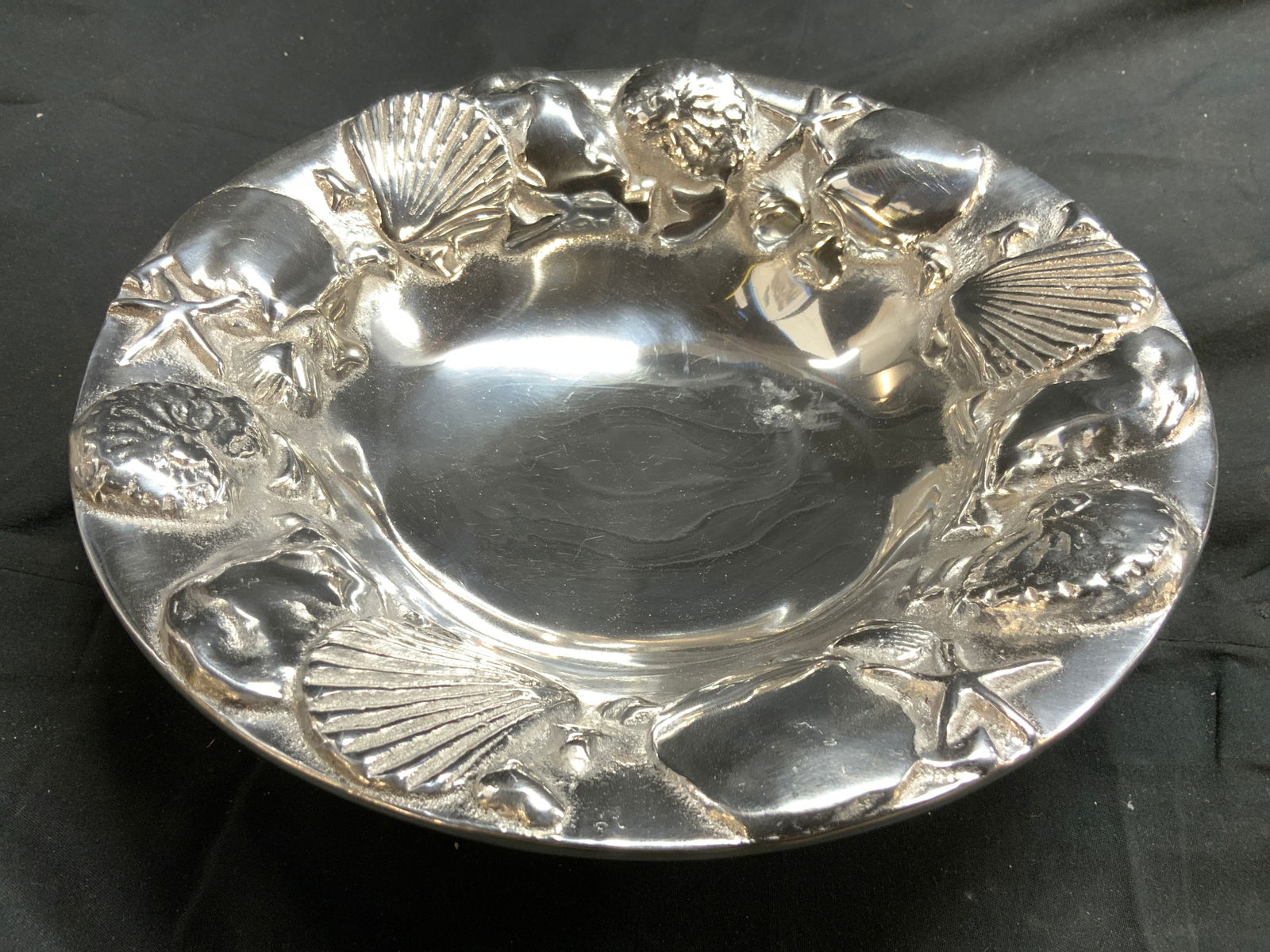MARIPOSA Silver Toned Pewter Bowl: Underside is inscribed MARIPOSA. Bowl is Silver toned, appears to be pewter. Bowl rim has beveled seashell, & starfish detail. Vessel measures approximately 9 inches diameter 2 inches tall. Bowl, meta