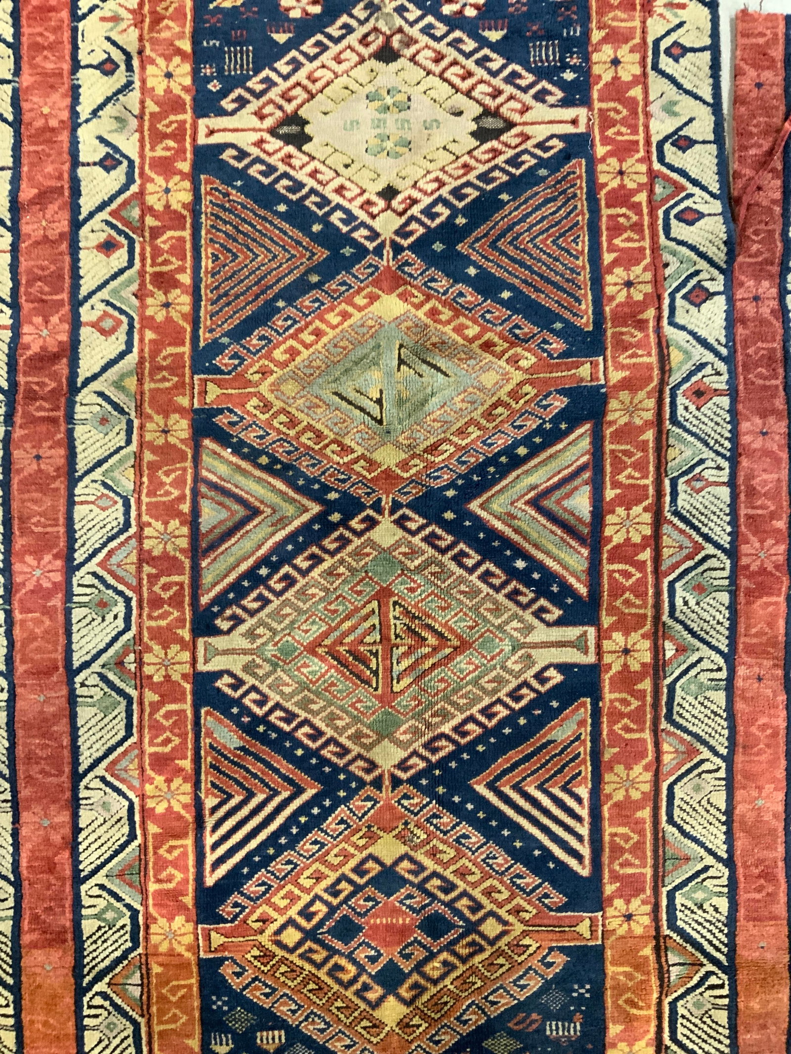 Vintage Handmade Wool Area Rug: Rug is handmade and wool. Piece measures approximately 62 inches long 37 inches wide. Rug, carpet, area rug, wool rug, vintage rug, fringed rug, handmade rug. Evident wear & tear.. 6RS