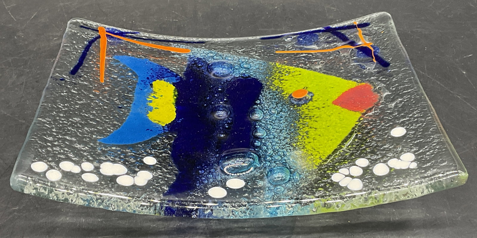 Multicolored Fish Motif Art Glass Plate: Multicolored Fish Motif Art Glass Plate. Bubble design throughout the glass. Reverse is textured. Silver tone metal ball feet to the underside. Measures approx.1.25H x 6.75W in. Chipping and surface w
