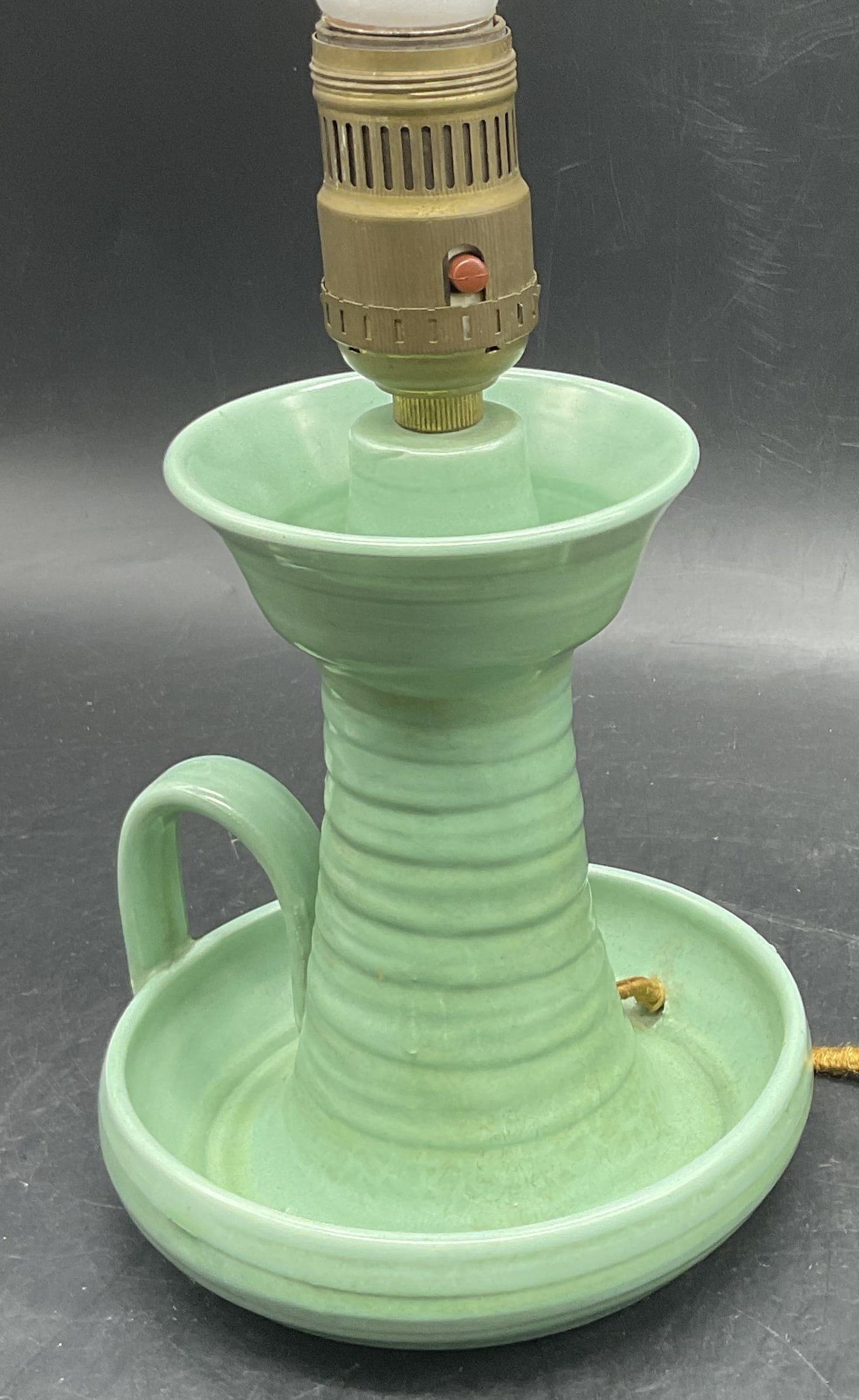 Vintage Green Pottery Portable Lamp: Vintage Green Pottery Portable Lamp. Measures approx. 11.5H x 5.25W in. Corded. Partial fabric to underside. Losses and shedding to cord. Not tested for function. Pitting and surface wear present. hom
