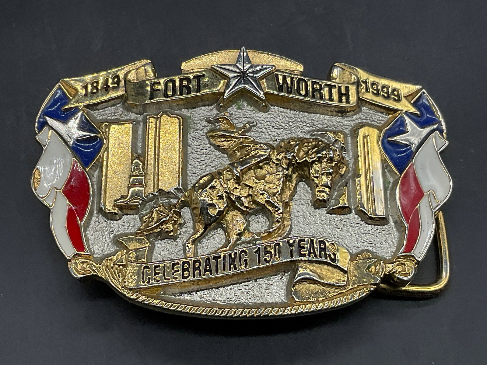 FORT WORTH USA 150th Anniversary Brass Buckle: FORT WORTH USA 150th Anniversary Brass Belt Buckle. Features a rider on horseback, the Texas flag, and the citys name and dates. Enamelwork to the obverse. Measures approx. 3.25W x 2.25L in. Reverse m