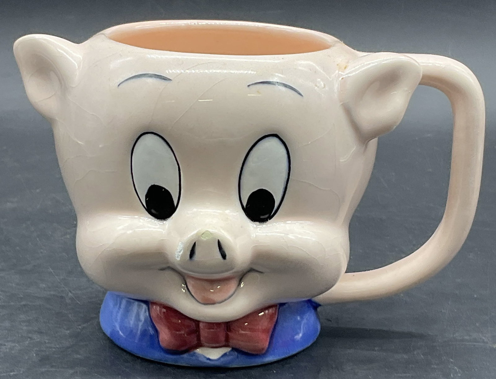 Vintage Ceramic Porky Pig Figural Mug: Vintage Ceramic Porky Pig Figural Mug. Measures approx. 4H x 5.25W in. Crazing, chipping, residue, and surface wear present. home decor, home accents, homewares, housewares, home accessories, collecti