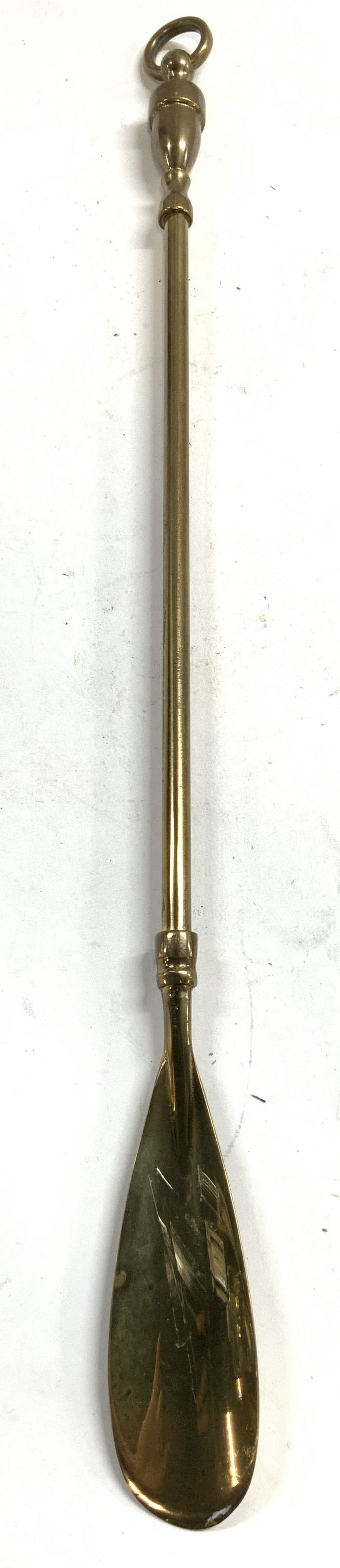 Vintage Inscribed Brass Shoe Horn: Backside of shoe horn is inscribed illegibly. Piece is gold toned and brass. Top of piece has loop form to hang on wall. Shoe horn measures approximately 18.75 inches long 1.5 inches wide. Shoe horn, 