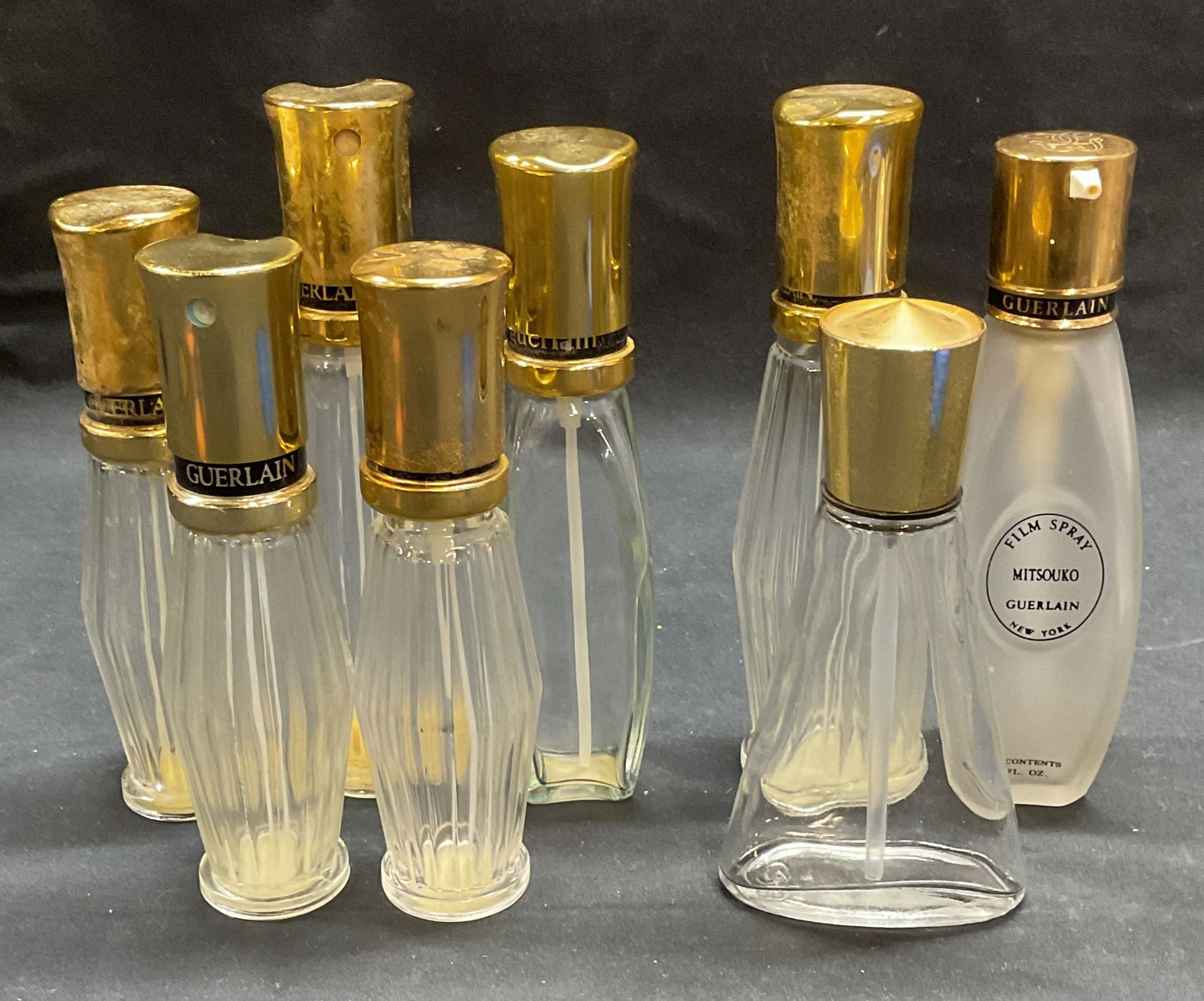 Group Vtg Guerlain Chamade & Mitsouko Bottles: Group lot of vintage Guerlain Chamade and Mitsouko perfume bottles. One bottle unmarked. Largest bottle approx 6.25 inches tall. All bottles empty. All pieces As Is, surface wear consistent with expos