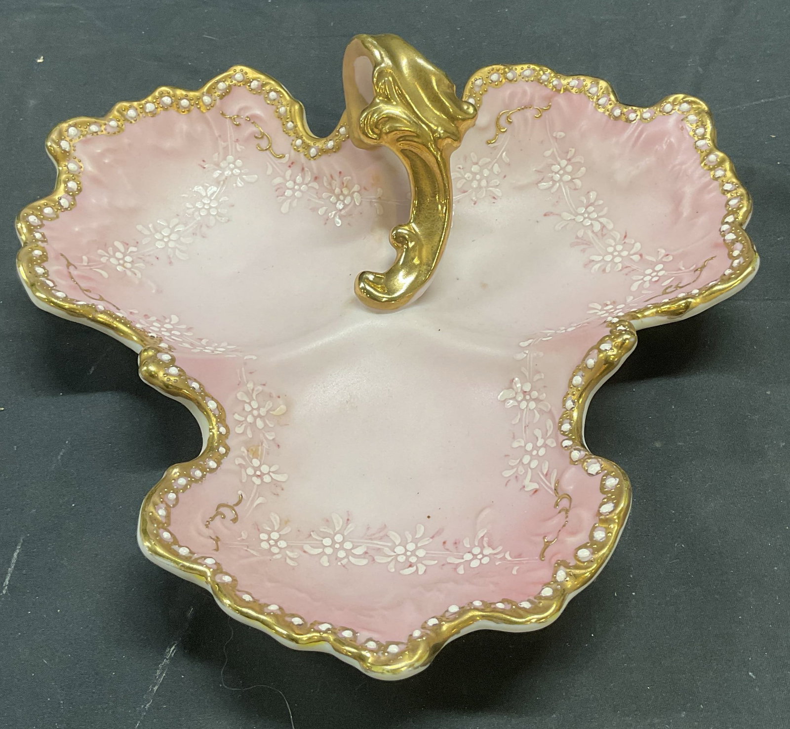 Signed Vintage Gilt Pink Porcelain Dish: Signed vintage porcelain dish with gilt decoration in pink. Hand painted floral design. Signed Y on underside. Measures approx 9.5 x 9.5 x 3 inches. Some scratching observed. Porcelain dish, candy dis