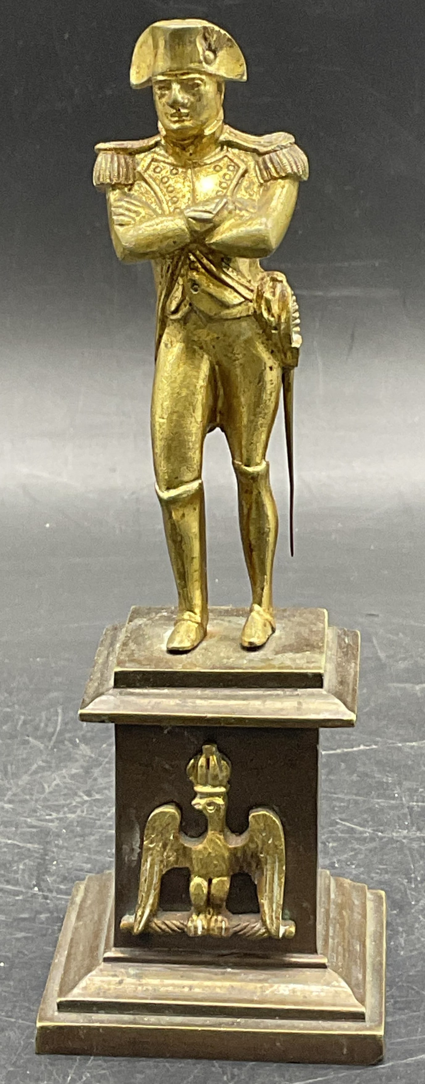 Vintage Gilt Bronze Napoleon Figural: A vintage Napoleon figural featuring bronze and gilt bronze. Napoleon is standing with his arms crossed and a sword on his hip. Measures approx. 6H x 2W in. Weighty piece. Patina present. Some surface