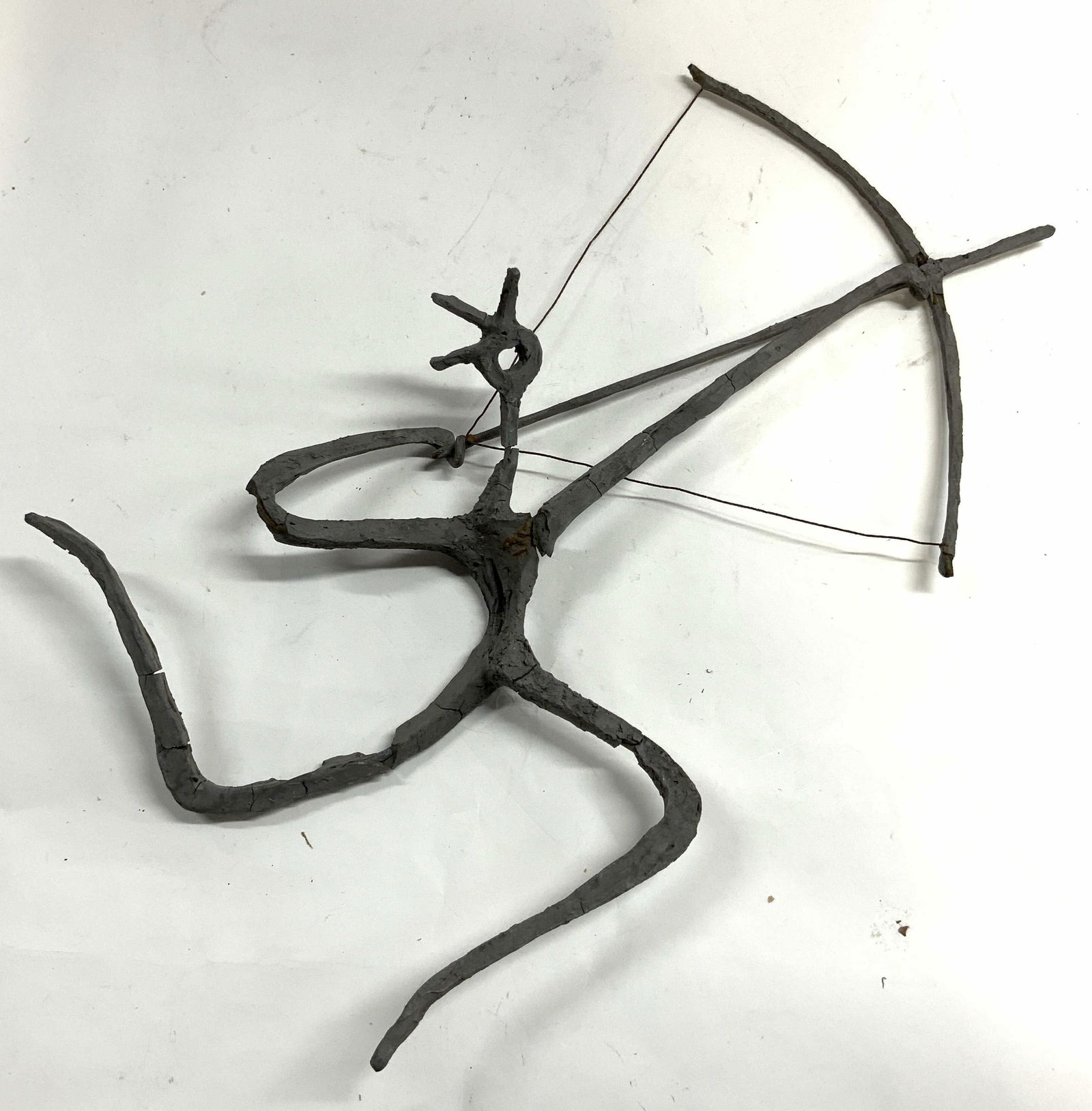 Clay Over Metal Archer Figure Sculpture: Sculpture appears to be clay over metal. Piece is dark slate toned. Depicts an archer figure with bow & arrow. Piece appears to be hand crafted. Sculpture measures approximately 16 inches wide 12.25 i