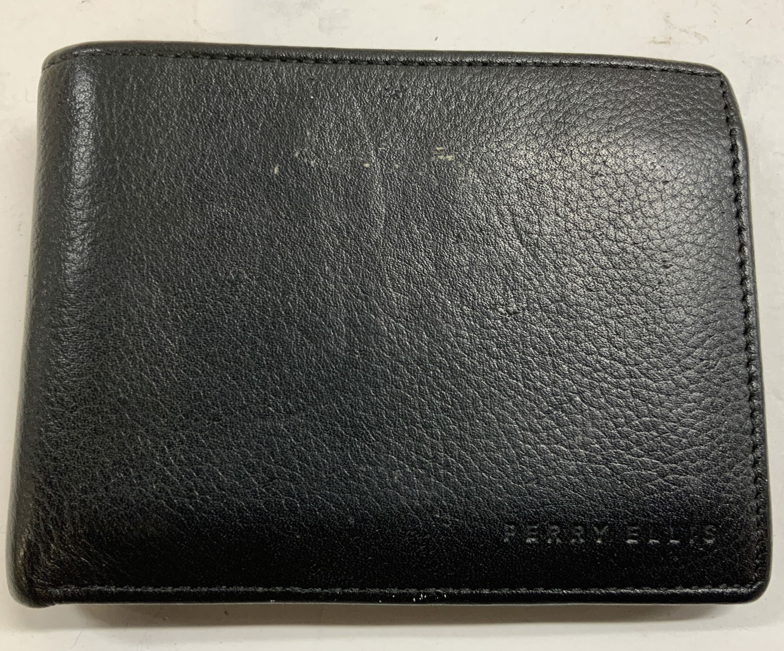 PERRY ELLIS Genuine Pebbled Leather Wallet: Wallet inscribed PERRY ELLIS GENUINE LEATHER. Wallet is black toned. Interior has 7 smaller pockets & 1 large bill pocket. Wallet measures approximately 3.5 inches tall 9 inches long when fully open.