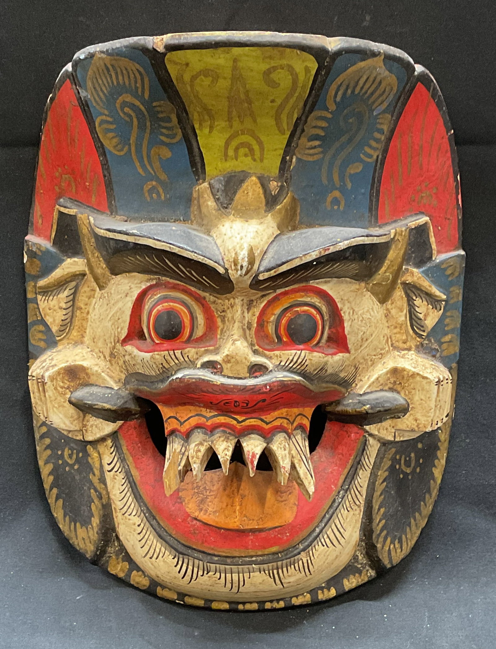 Vintage Asian Carved Wood Mask: Vintage Asian carved wood mask. Hand painted with decorative patterns and gilt accents. Measures approx. 8.5 x 6.75 inches. Some surface wear including small chips and loss to paint observed. Wood mas