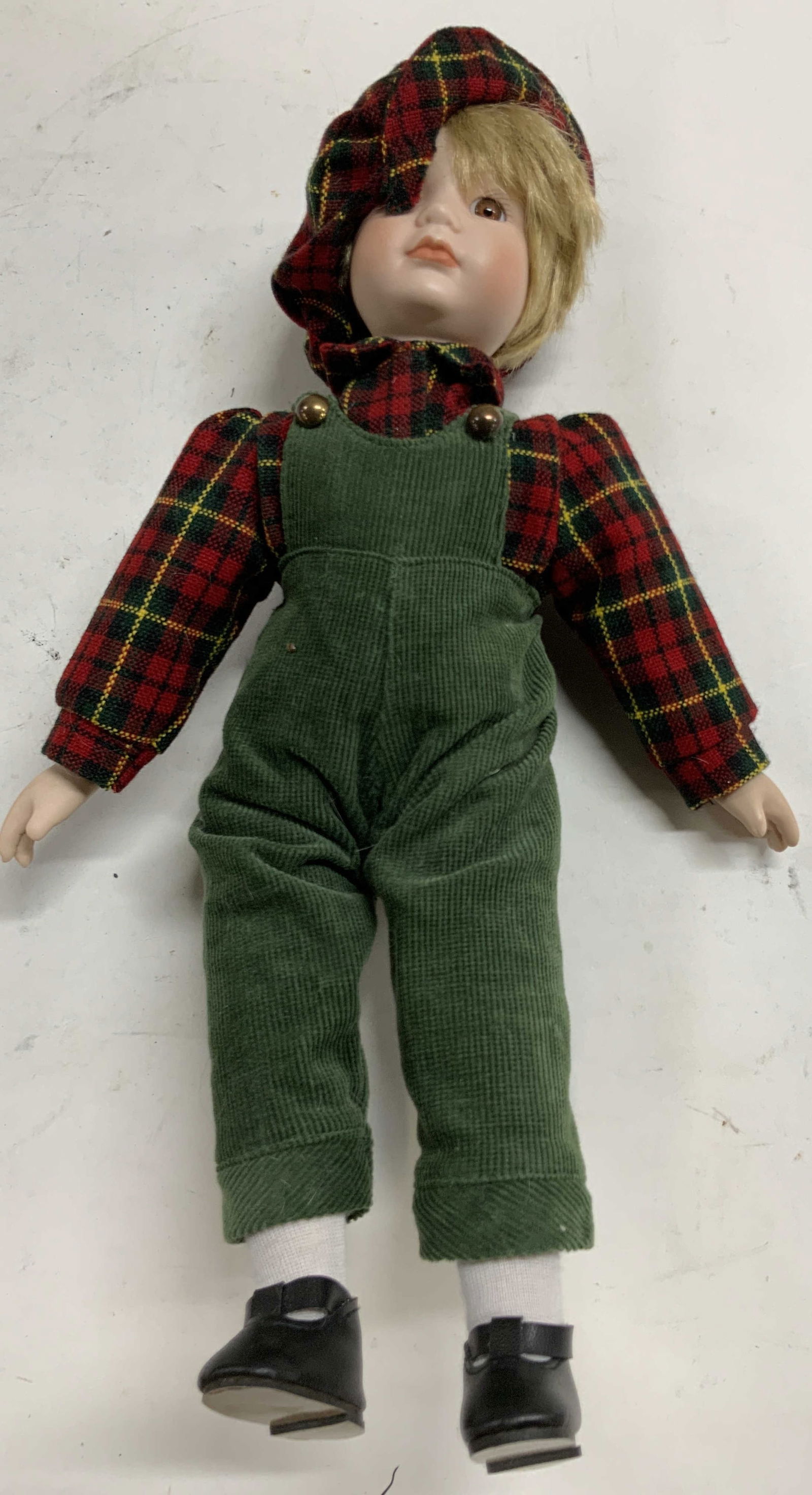 The Heritage Mint Collection Vtg Boy Porc Doll: Doll appears to be THE HERITAGE MINT COLLECTION. (No apparent markings). Depicts a male child figure wearing plaid shirt and hat with green corduroy overalls. Doll hand and head are porcelain. Piece m