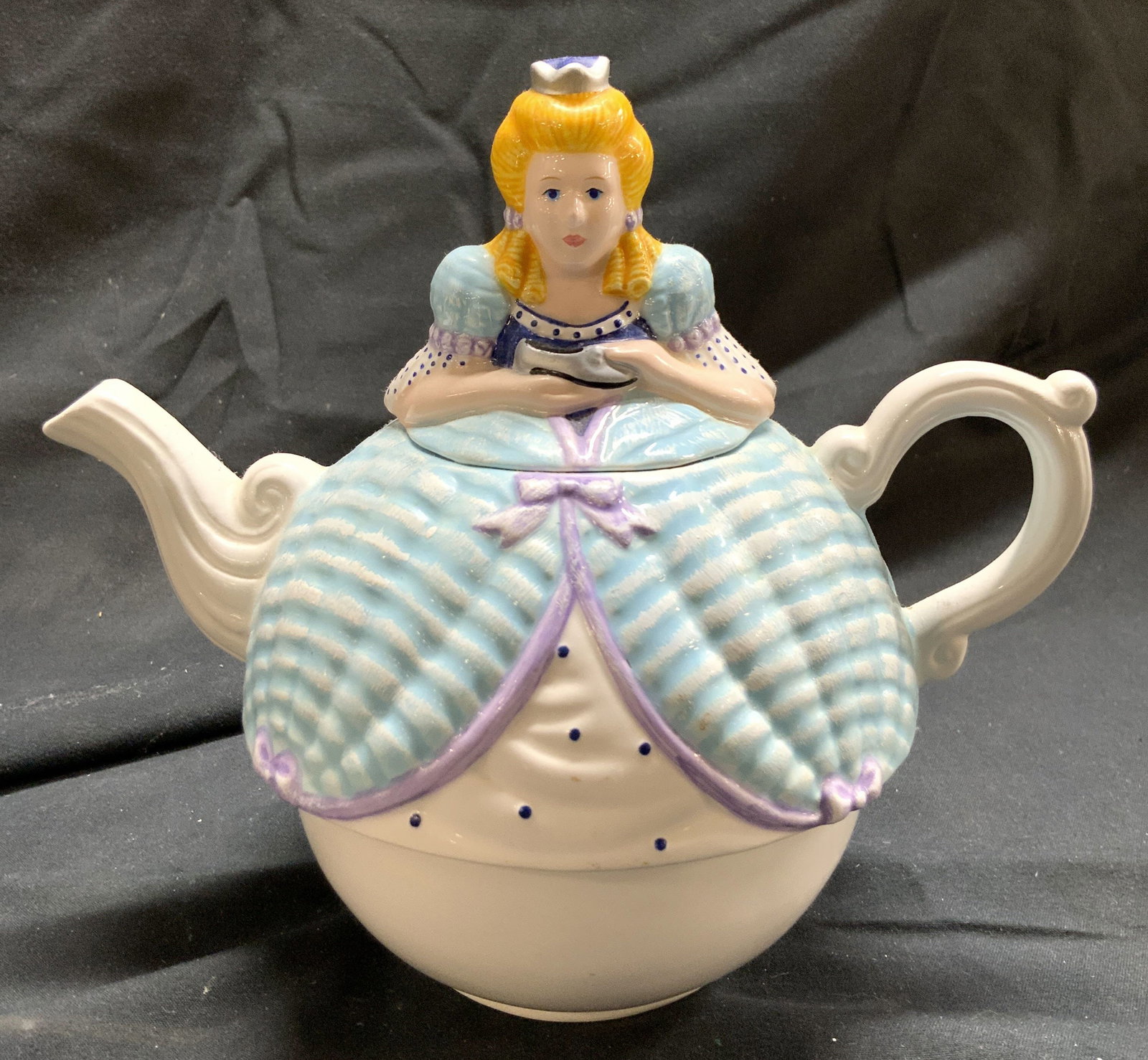 DEPARTMENT 56 Porc Cinderella Teapot W Lid: Tag on underside reads DEPARTMENT 56. Teapot is porcelain. Piece includes lid. Piece depicts a Cinderella wearing a ball gown holding a slipper. Piece measures approximately 6 inches tall 6.75 inches 
