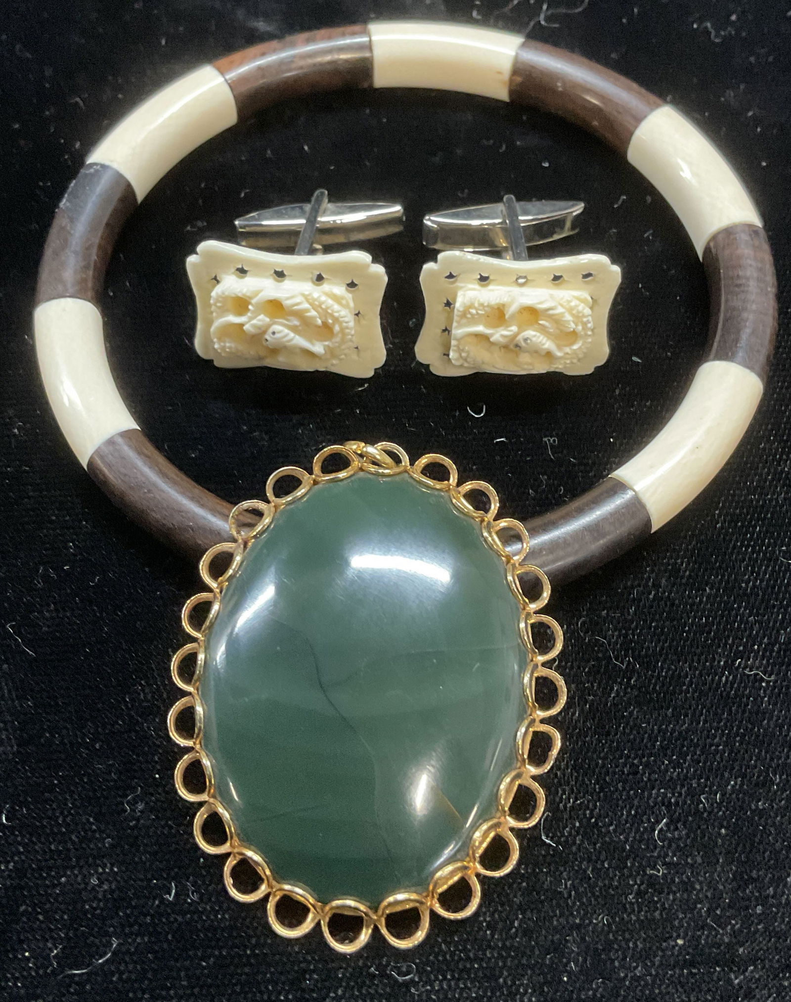 Lot 3 Onyx Pendant, Bone cufflinks, Bone Bracelet: Lot of 3 jewelry pieces. Gold tone and green onyx pendant, bone and horn bangle bracelet, and carved bone cufflinks. Bracelet measures approx 2.5 inches wide, pendant approx 1.75 x 1.5 inches, cufflin