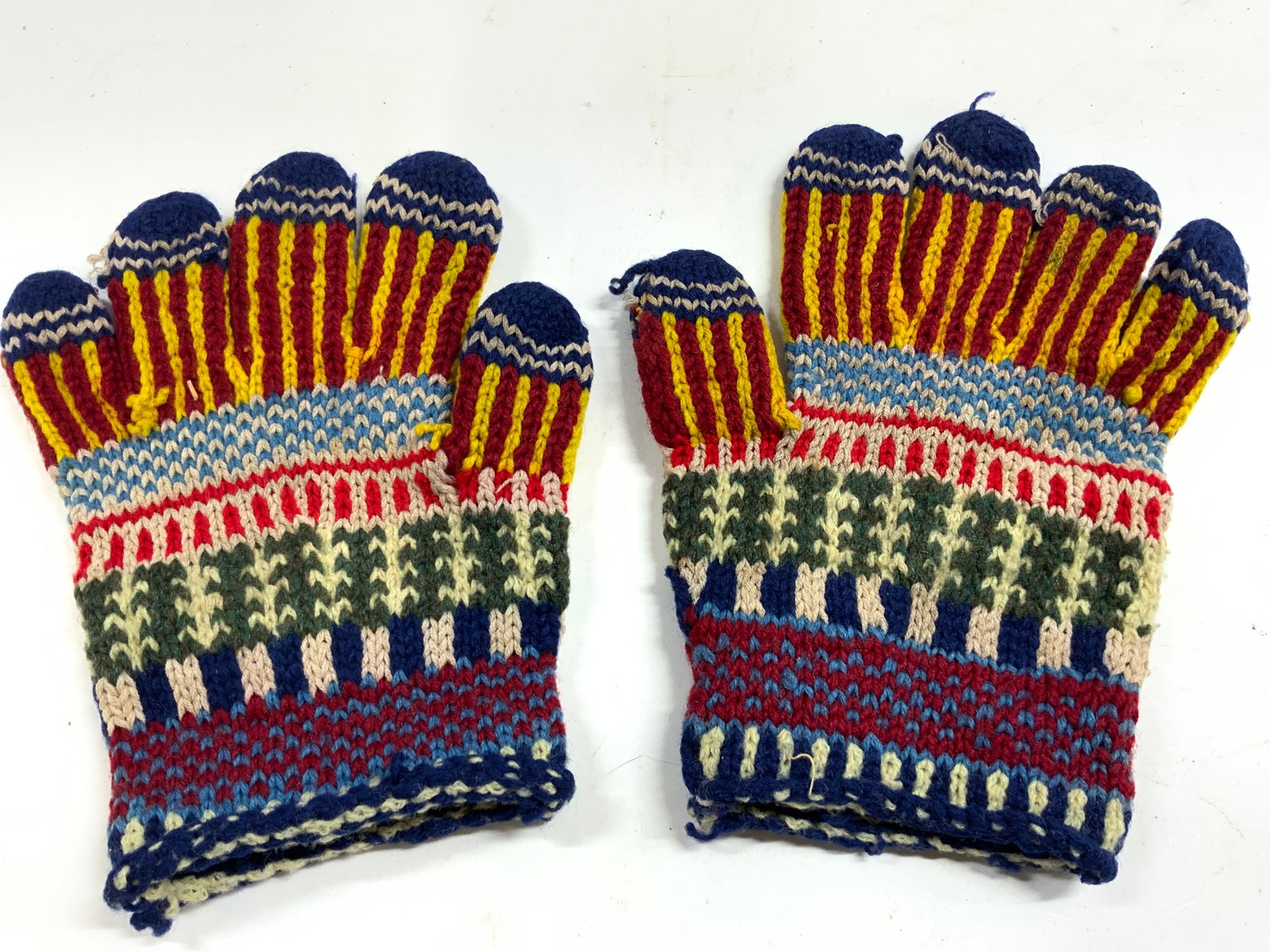 Pair Hand Knitted Woven Wool Gloves: Lot includes a pair of gloves. Each appear to be hand knitted woven wool possibly cotton. Gloves have multi toned patterned details. Each glove measures approx 7.25 inches tall 6 inches wide while lay