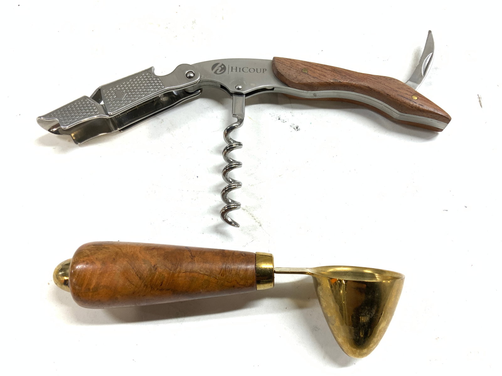 Lot 2 Coffee Scoop & Wine Corkscrew: Lot includes 1 wooden and brass coffee scoop & 1 HI COUP Trademarked corkscrew. Coffee scoop has beige toned handle. Corkscrew measures approximately 7 inches long when fully open 4.5 inches when clos