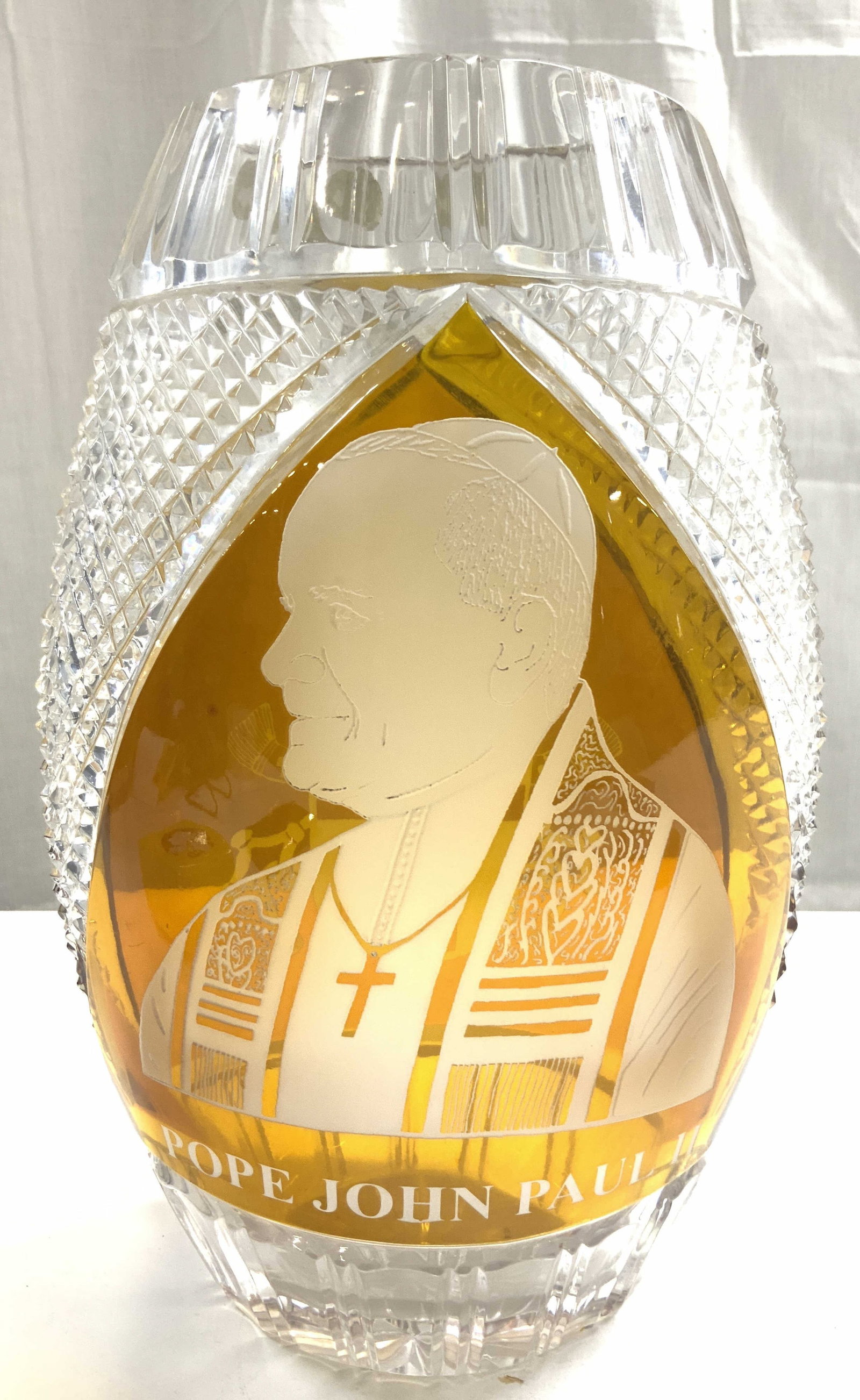 JULIA Crystal Glassworks Poland Crystal Vase: Tag reads JULIA MADE IN POLAND. Vase is crystal. Piece has amber toned areas & frosted Pope John Paul II, & Coat of arms detail. Relief pattern to outer rim. Vase also has diamond form relief detail P
