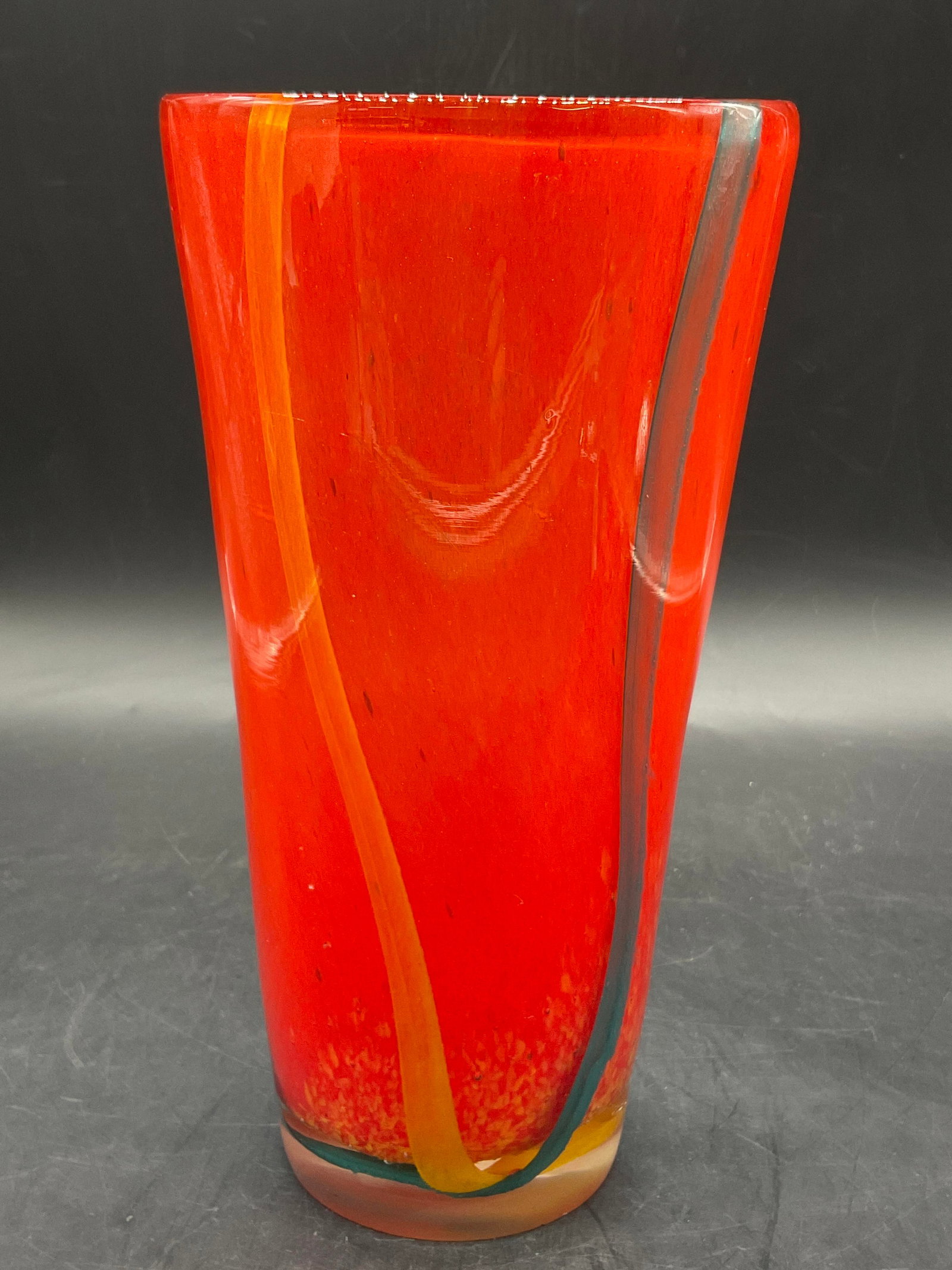 Swirled Orange Art Glass Vase: Swirled Orange Art Glass Vase. Blue and yellow hues throughout the orange. Thick walled. Measures approx. 9H x 4.5W in. Bubbles to glass. Chipping and surface wear present. home decor, home accents, h