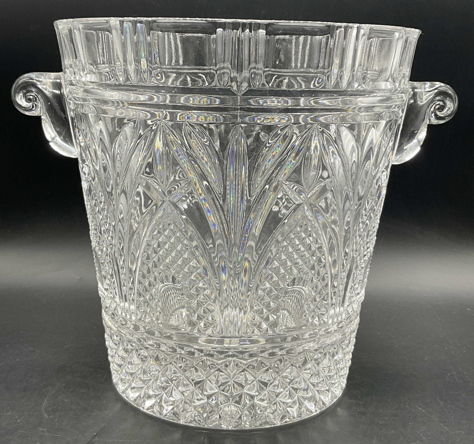 Cut Glass Scrolled Handle Ice Bucket, 10 Inch Ht: Cut Glass Scrolled Handle Ice Bucket. Colorless glass. Thick walled and weighty. Measures approx. 10H x 12W in. Width includes handles. Chipping, surface wear, and bubbles present. Seam present. home 