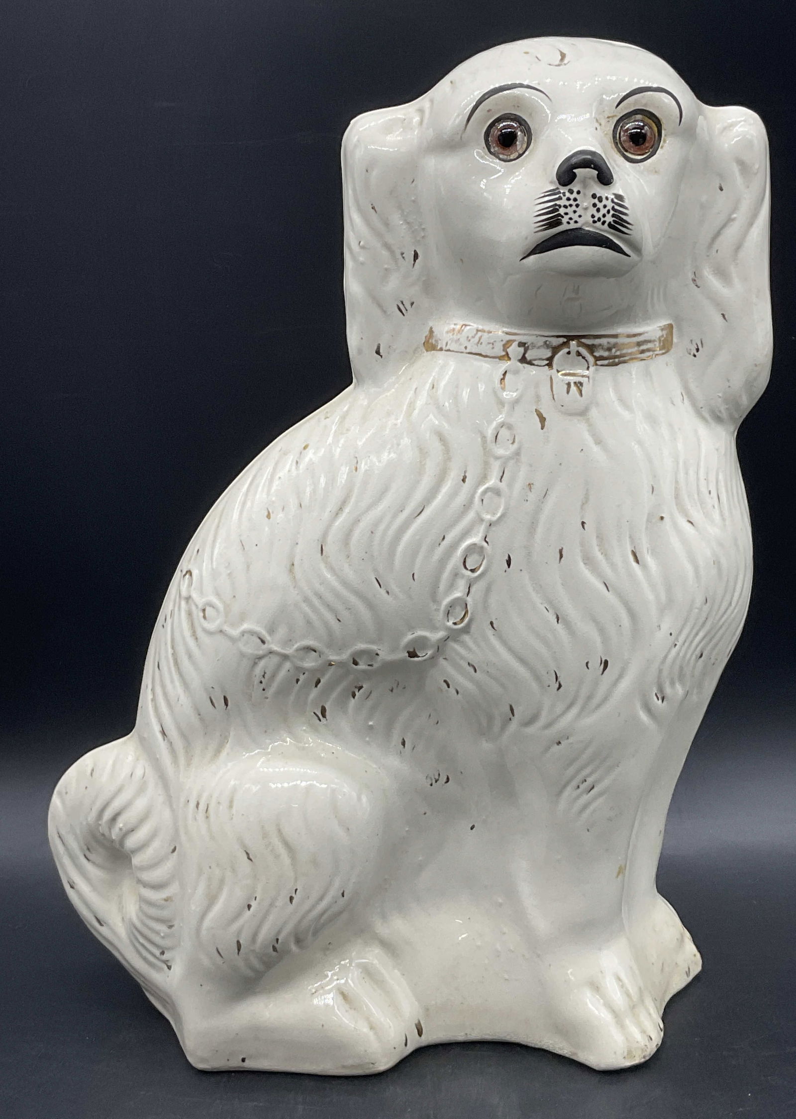 Vintage Ceramic Staffordshire Spaniel Dog Statue: Vintage Ceramic Staffordshire Spaniel Dog Statue. Glass eyes to the piece. Hand painted details. Weighty piece. Measures approx. 13H x 8.5W in. Holes to reverse and underside. Seam present. Losses to