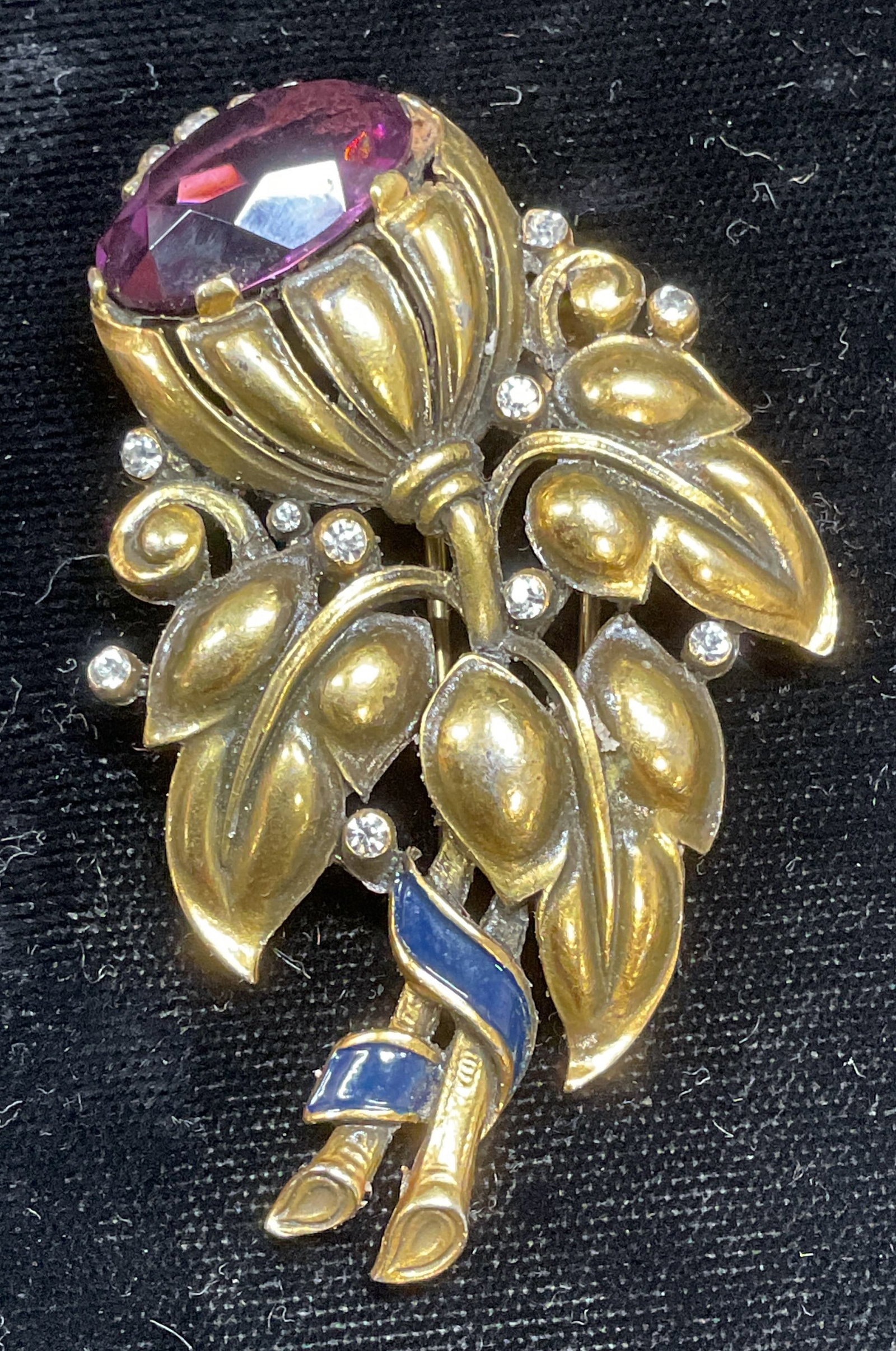 Vintage Trifari Gold Tone Crystal Flower Fur Clip: Vintage Trifari fur clip. Gold tone flower motif with purple and colorless crystal. Signed on clip. Measures approx 2.5 x 1.5 inches. Some wear including scratching observed. Jewelry, estate jewelry,