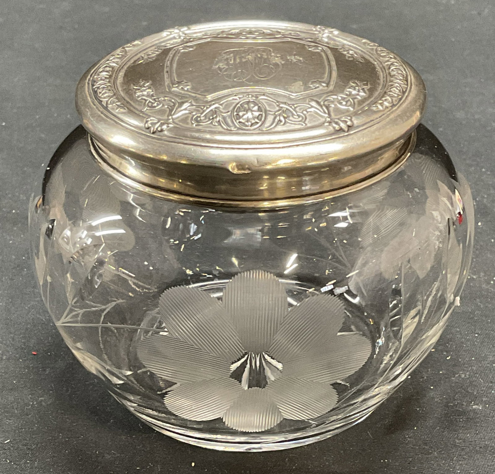 Vintage Sterling Silver Cut Crystal Dresser Jar: Vintage cut crystal dresser jar with sterling silver lid. Monogram etched on lid. Raised scroll pattern. Marked sterling. Bowl with floral pattern. Measures approx 4 x 3 inches. Some surface wear incl