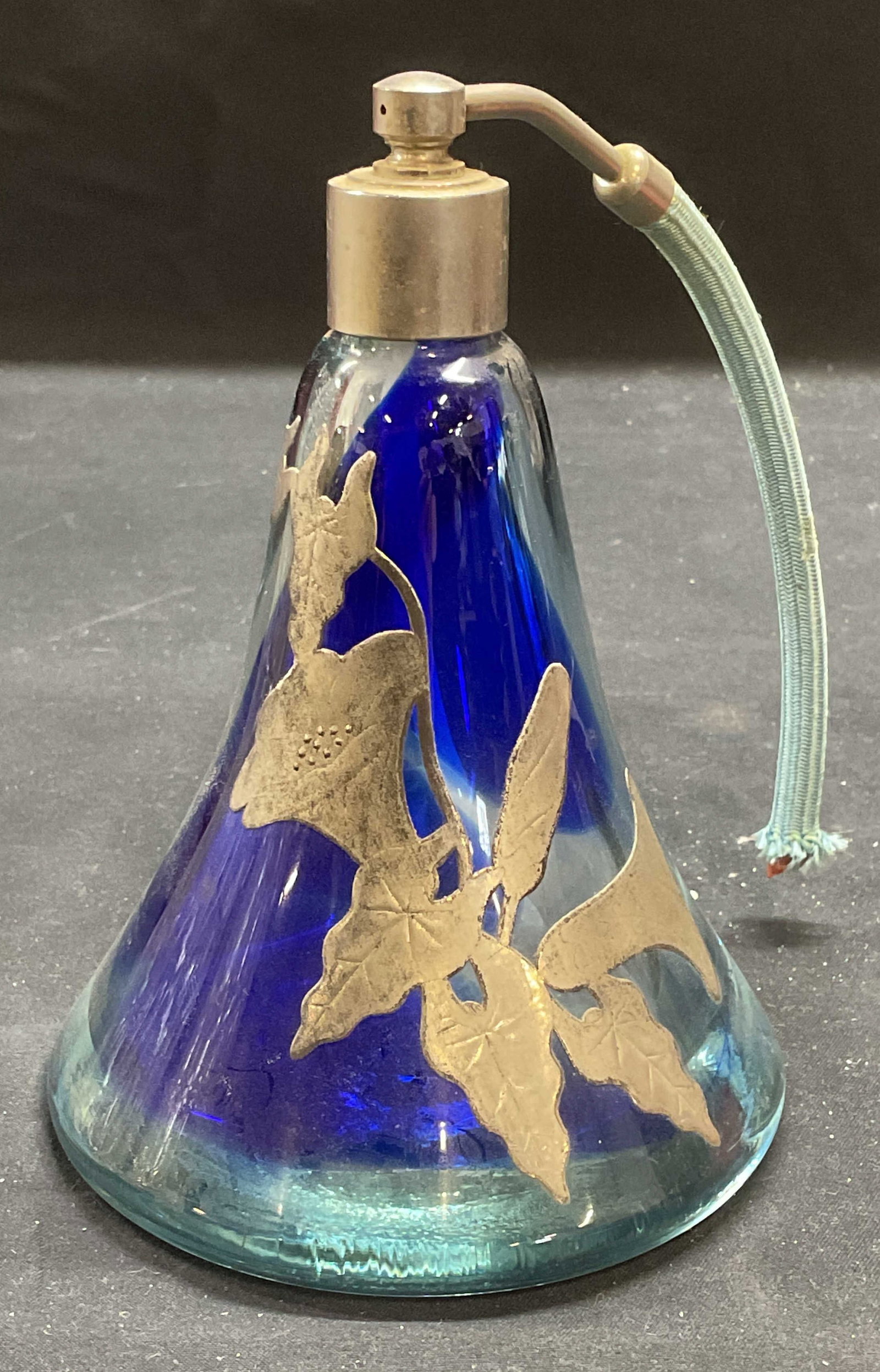 Luzoro Silver Tn Art Glass Perfume Bottle France: Michele Luzoro hand blown art glass perfume bottle in blue with silver tone metal overlay. Floral design. Signed on underside. Dated 1985. Made in France. Piece had weight. Measures approx 4 x 5.5 inc
