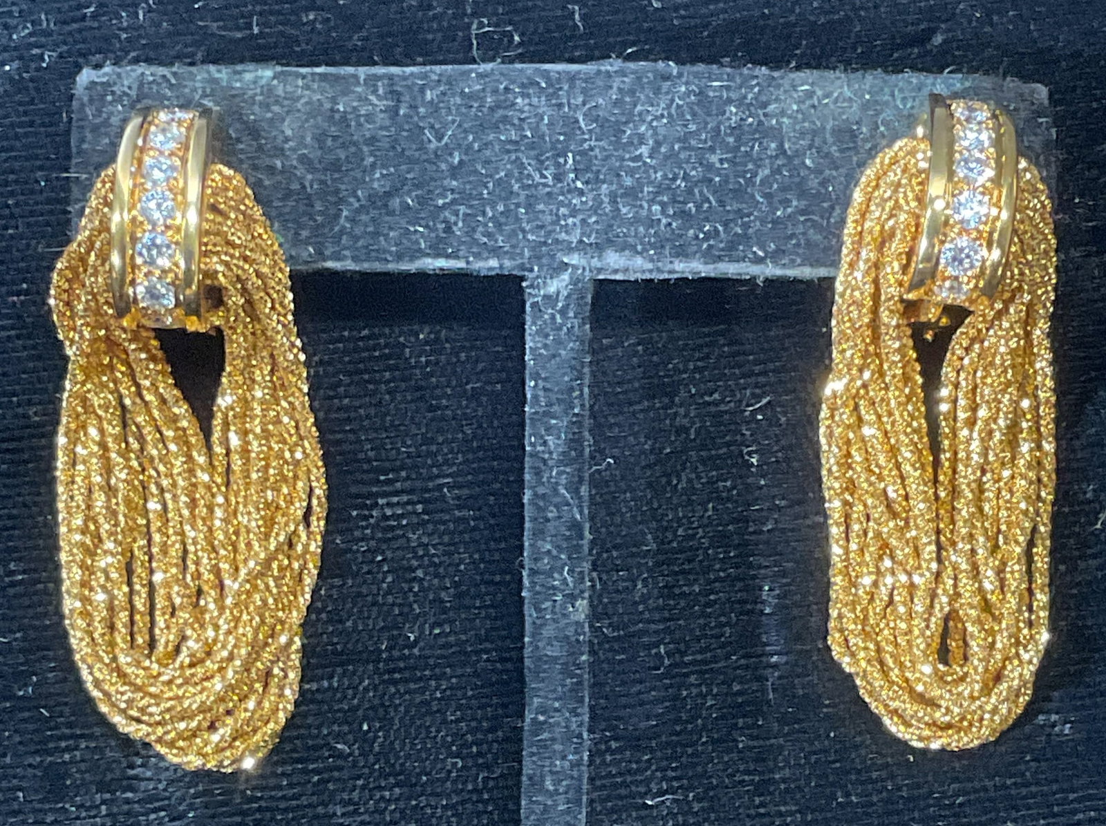 18K GOLD .25CT DIAMOND CHAIN EARRINGS: 18k gold earrings with dangling twisted rope chains. Half hoop center with round cut diamond setting down band. Earrings approx 1 7/8 inches long. Approx .25 carat diamond weight. Total weight 24.9 gr