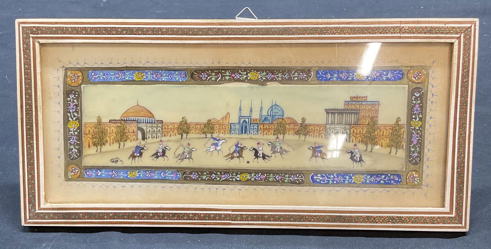 Framed Persian Miniature Polo Game Painting: Framed Persian miniature painting. View of a mosque courtyard with figures on horseback playing polo. Possibly watercolor on bone. Framed in decorative Khatam inlay frame. Not examined out of frame. F