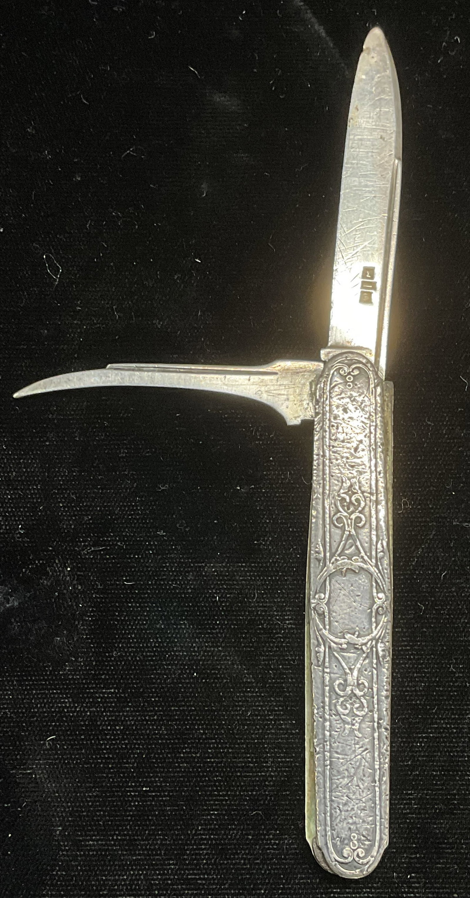 Antique Sterling Silver Paring Knife & Pick: Sterling silver paring knife with pick. Raised decorative scroll exterior case. Knife blade approx 2.5 inches long. Case approx 3.25 inches long. Anchor sterling hallmark on knife blade. Other hallmar