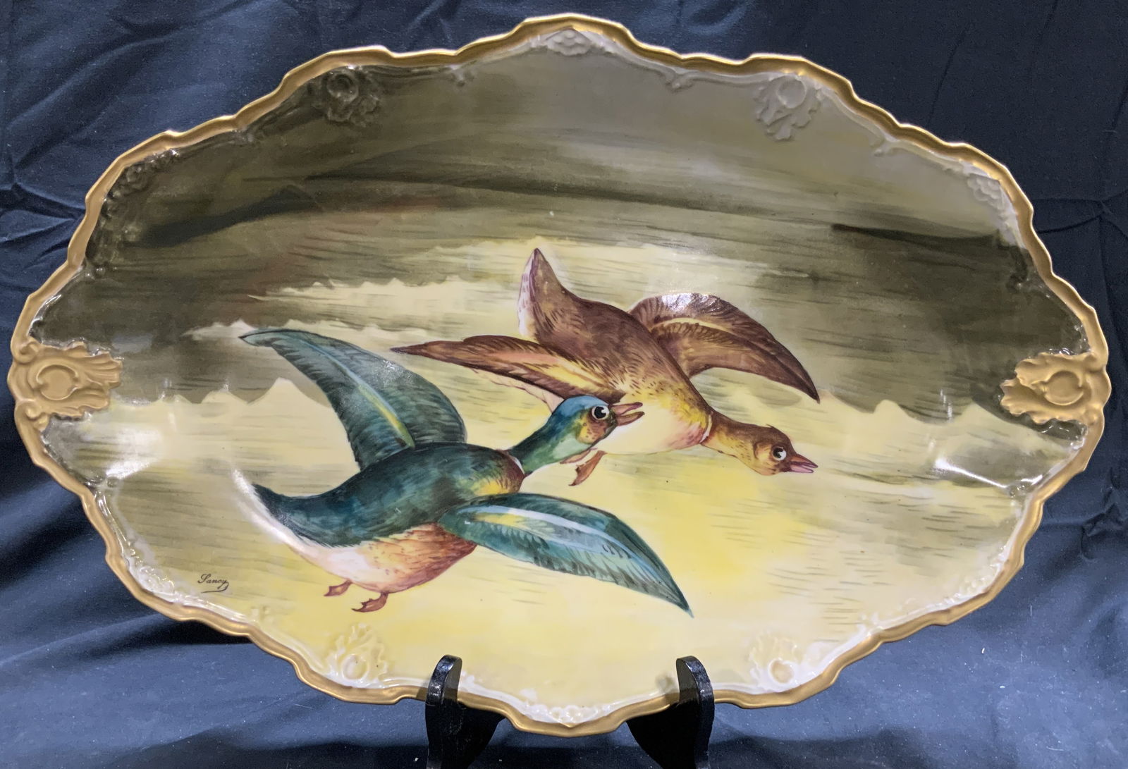 LRL LIMOGES FRANCE Vntg Porc Duck Serv Dish: Underside is marked LRL LIMOGES FRANCE. Piece is vintage and porcelain. Dish has detail of ducks flying. Piece has gilt rim. Serving dish measures approx 19 inches wide 12.5 inches deep 2.25 inches ta