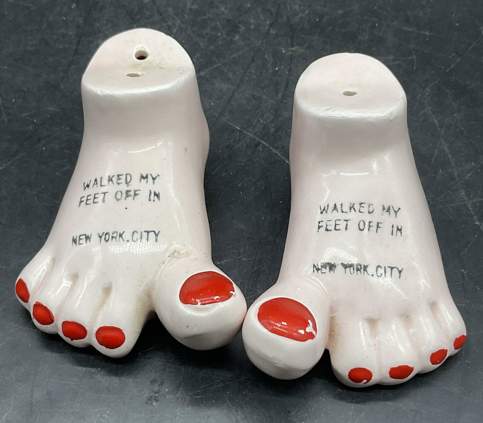 Vintage WALKED MY FEET OFF IN NYC Ceramic Shakers: Pair Vintage WALKED MY FEET OFF IN NEW YORK CITY Ceramic Salt & Pepper Shakers. Foot form shakers. Measures approx. 1.5H x 3W in. Measured at widest point. Sticker to underside reads Japan. Stoppers t