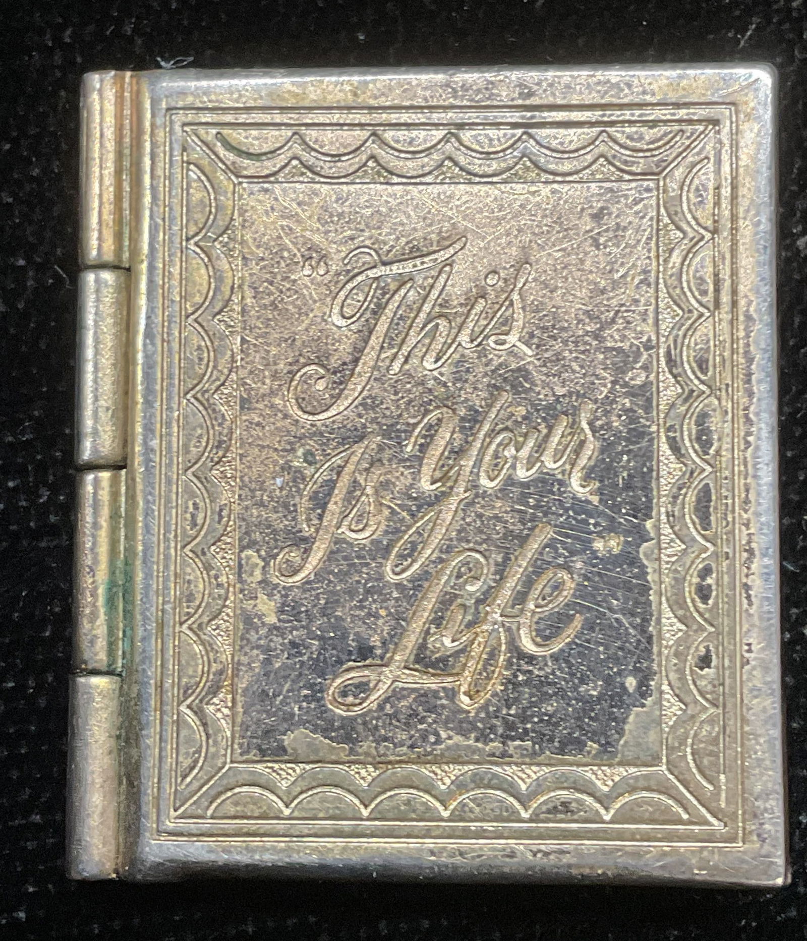 Vintage Gold Plated Your Life Book Locket: Vintage gold plated book motif locket. Reads This Is Your Life on exterior. Two slots for photos on interior. Measures approx 1 x 7/8 inches. Some surface wear including scratching observed. Jewelry,