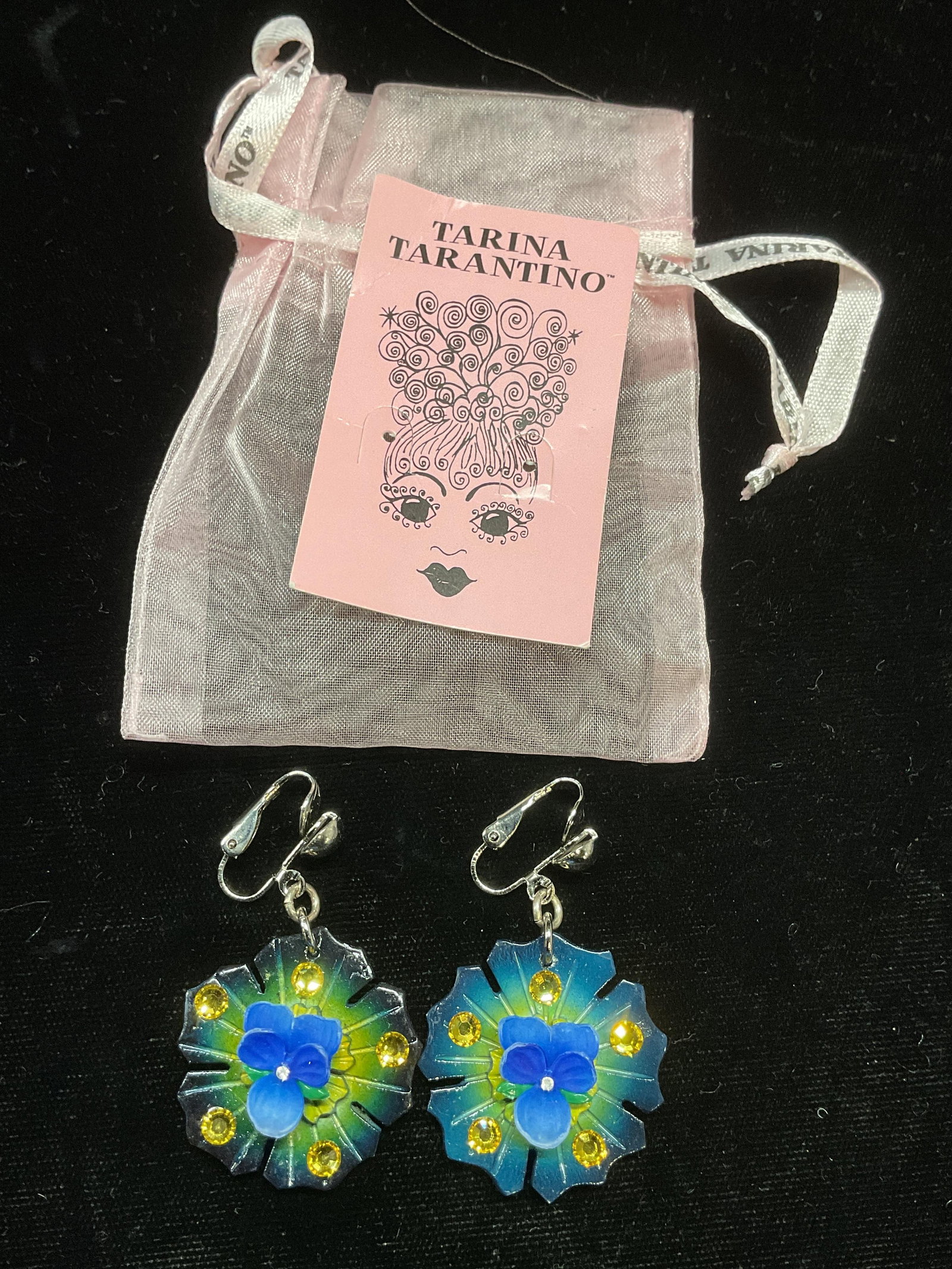 Vtg Tarina Tarantino Blue Crystal Flower Earrings: Vintage Tarina Tarantino blue and green toned flower clip on earrings with Swarovski crystal elements. Signed on underside. Includes jewelry pouch. Measure approx 1.75 inches long. Some surface wear i
