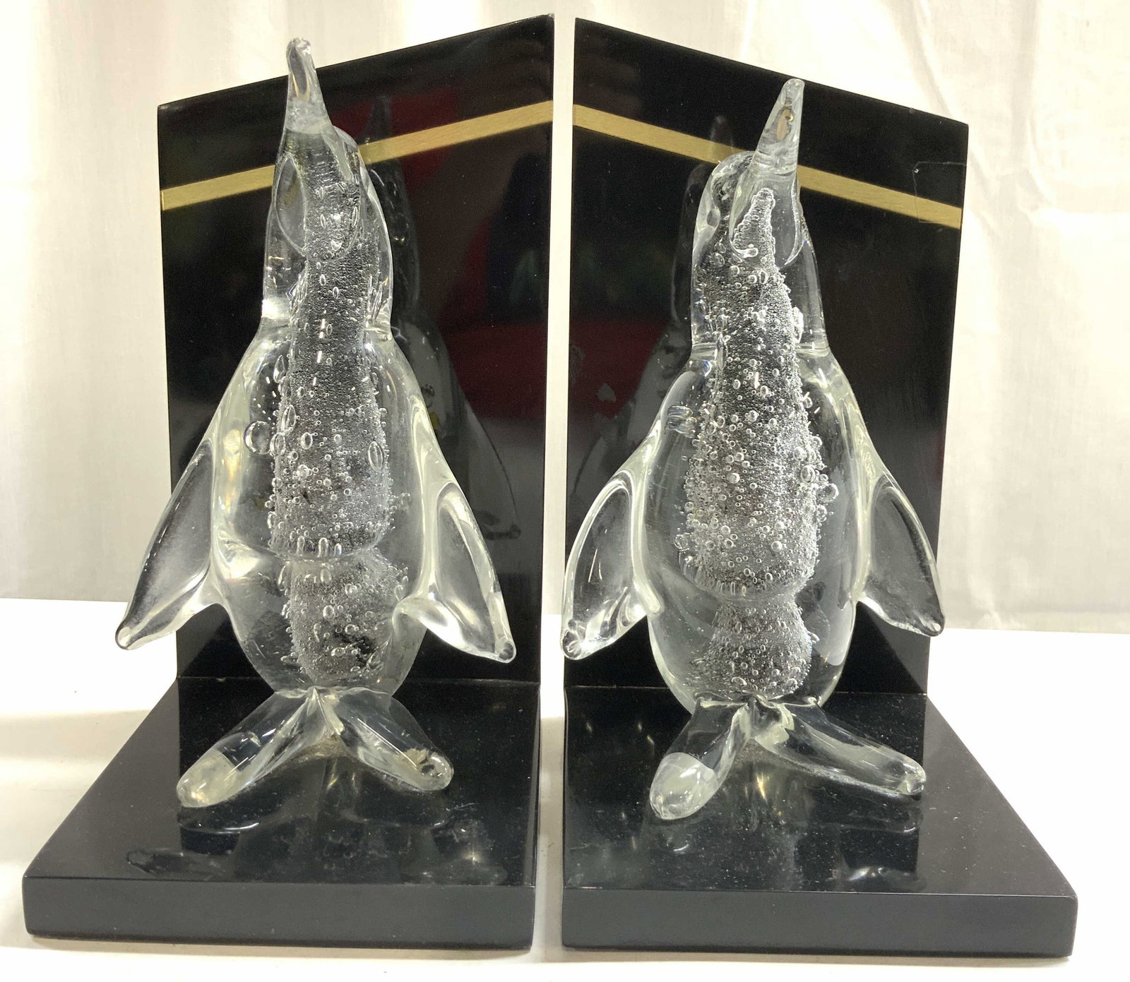Vtg Pr Italian Penguin Bubble Blown Gls Bookends: Bookends are vintage. Each piece is glass and has bubble blown penguin sculpture figures. Each figure stand on black toned bases. Near tops of pieces have strips of gold toned brushed metal areas (pos
