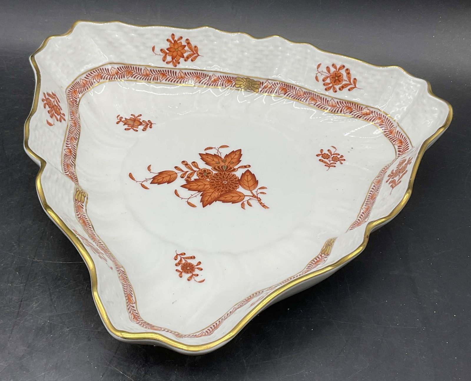 HEREND HUNGARY Hand Paint Porcelain Triangle Bowl: HEREND HUNGARY Hand Painted Porcelain Triangle Bowl. Orange toned floral motif alongside gilt line work. Scalloped rim. Signed HEREND HUNGARY HAND PAINTED. Measures approx. 2H x 10W in. Surface wear a
