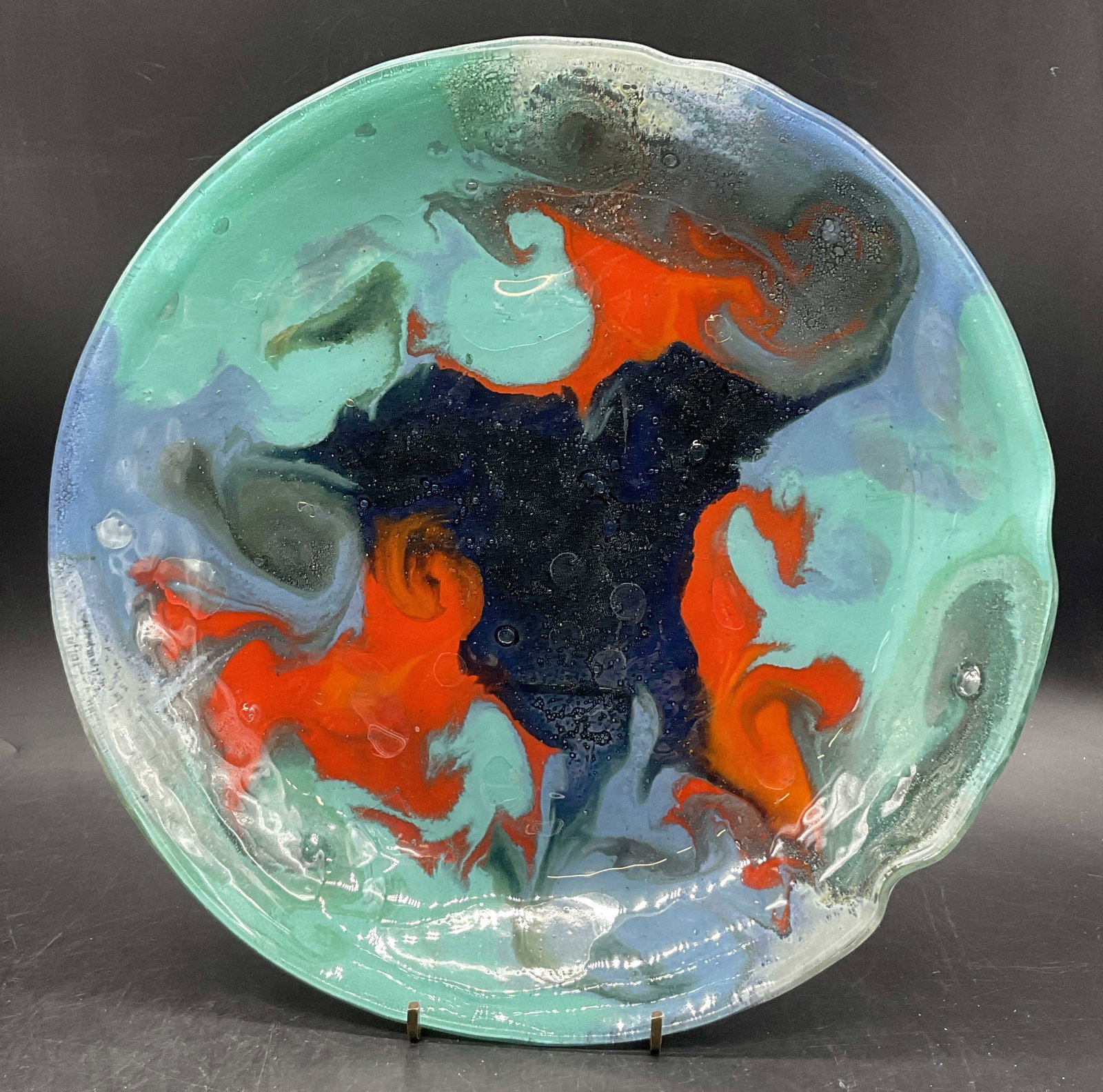 Orange & Blue Swirled Art Glass Serving Dish: Handmade Orange & Blue Swirled Art Glass Serving Dish. Shallow bowl. Raised bubbles to the piece. Measures approx. 11.25W x 1.5H in. Surface wear consistent with age, use, and exposure. home decor, ho