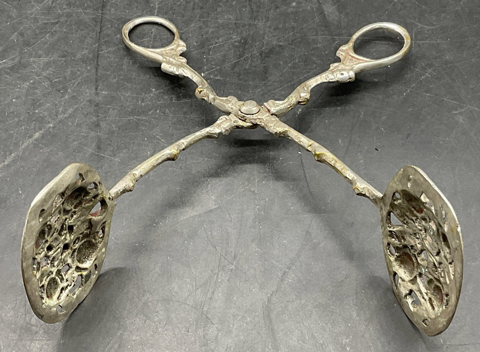 Vintage Silver Tone Metal Menorah Motif Tongs: Vintage Silver Tone Metal Menorah Motif Tongs. Brass hues throughout. Measures approx. 6.5L x 2W in. Some discoloration, surface wear, and loose pieces present. home decor, home accents, homewares, ho