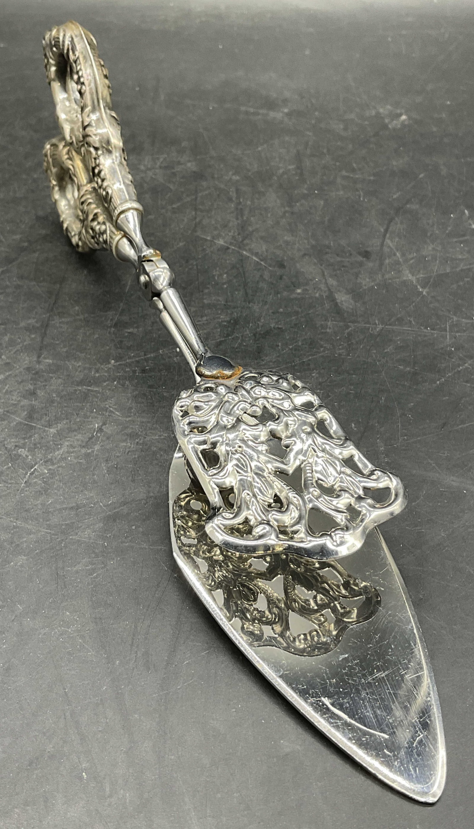 AMBASSADOR ITALY Vintage Sterling Handle Tongs: AMBASSADOR ITALY Vintage Sterling Handled Tongs. Crafted from silver tone metal and sterling. Center hardware marked AMBASSADOR ITALY. Handle marked STERLING. Measures approx. 10.25W x 3L in. Total we