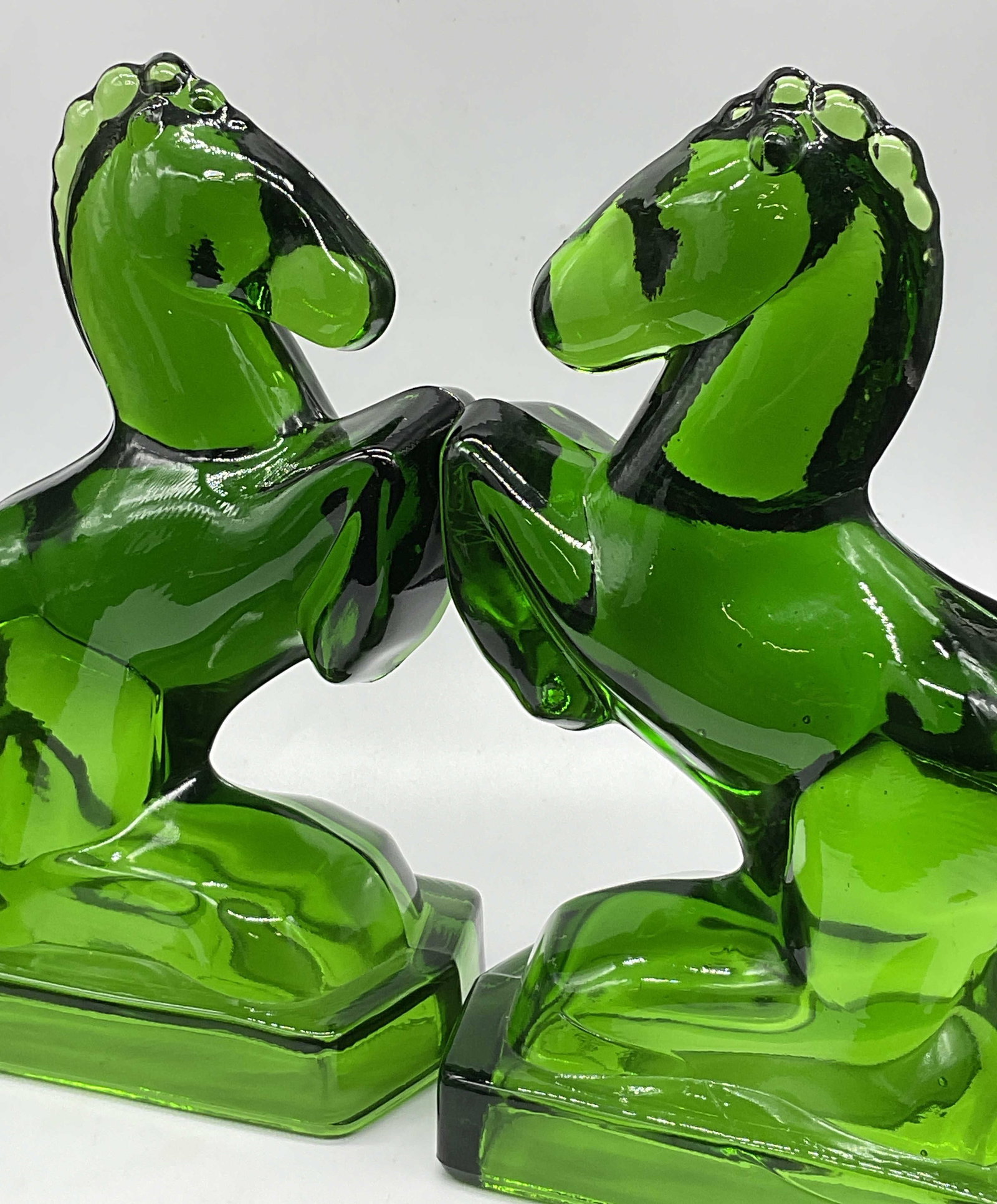 Pair Vintage Green Glass Horse Bookends: Pair Vintage Green Glass Horse Bookends. Measures approx. 8.25H x 5.25W in. Seam present. Bubbles to glass. Surface wear consistent with age, use, and exposure. Rough edges to glass. home decor, home 