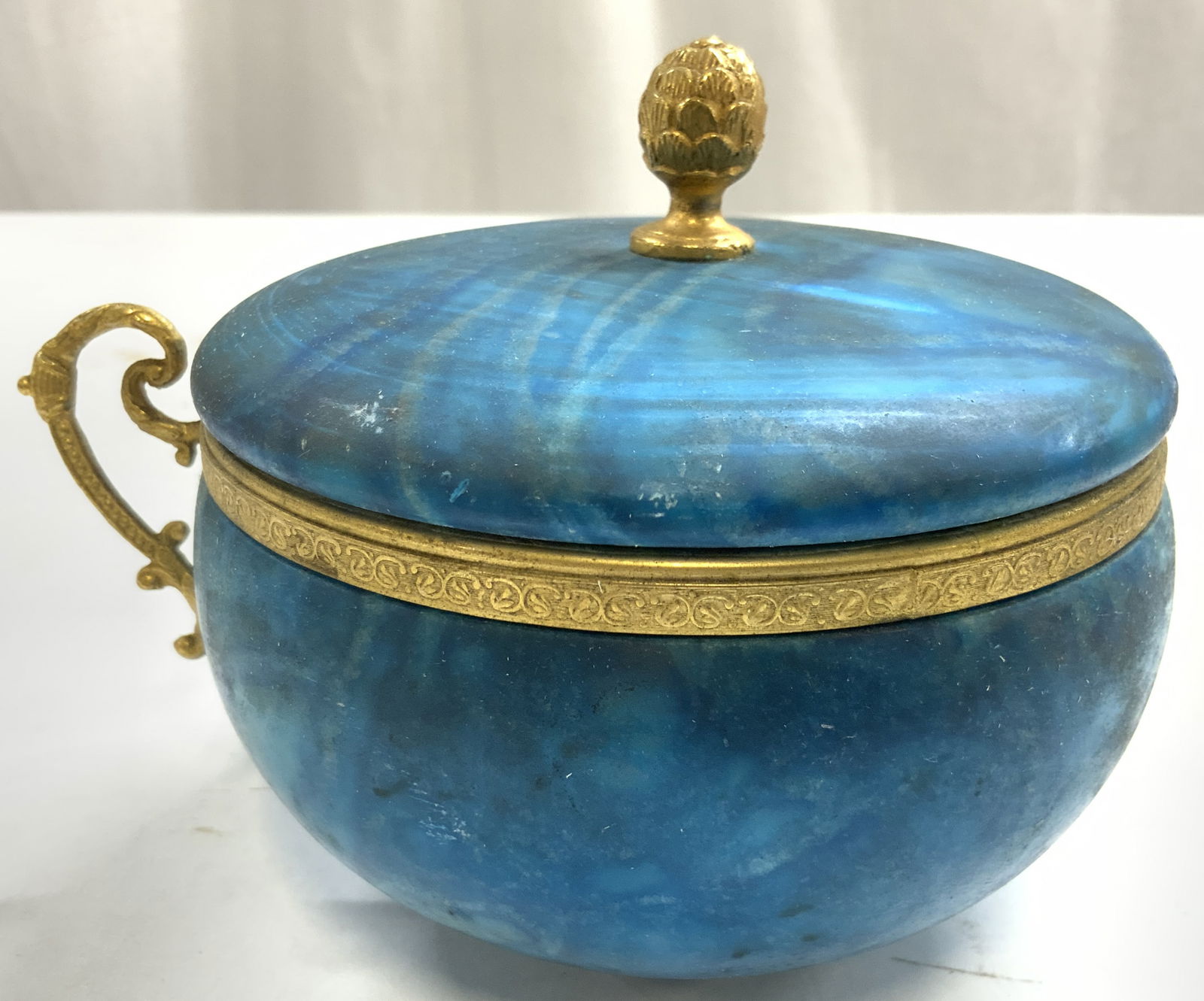 Vntg Dyed Marble & Gilt Vessel W Lid & Handle: Vessel is vintage. Piece is blue toned dyed marble with gilt artichoke form finial, rim & scrolled handle. Piece measures approximately 5.75 inches wide 4.25 inches tall, 4.75 inches deep. Vessel, vin