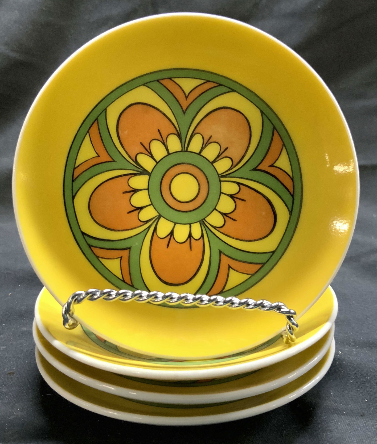 Set 4 Floral Detailed Porcelain Bread Plates: Lot includes 4 bread plates. Each are porcelain. Bread plates each have yellow, green, and orange toned floral detail. Exteriors are white toned. Each piece measures approx 4.5 inches diameter. Bread