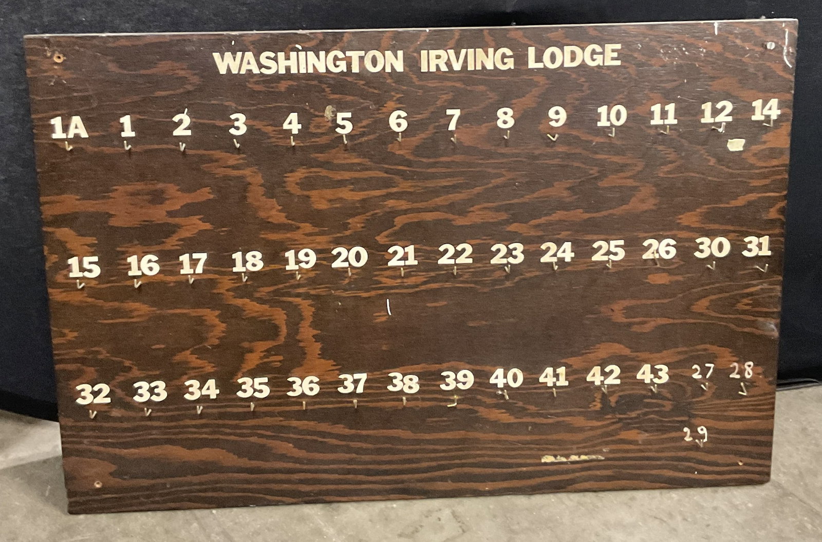 WASHINGTON IRVING LODGE Key Holder Sign: WASHINGTON IRVING LODGE Key Holder Sign. Numbers 1A to 29. Brown hued wood board with white hued numbers. Metal pegs below numbers. Measures approx. 24L x 36W in. Losses, discoloration, wear to metal,
