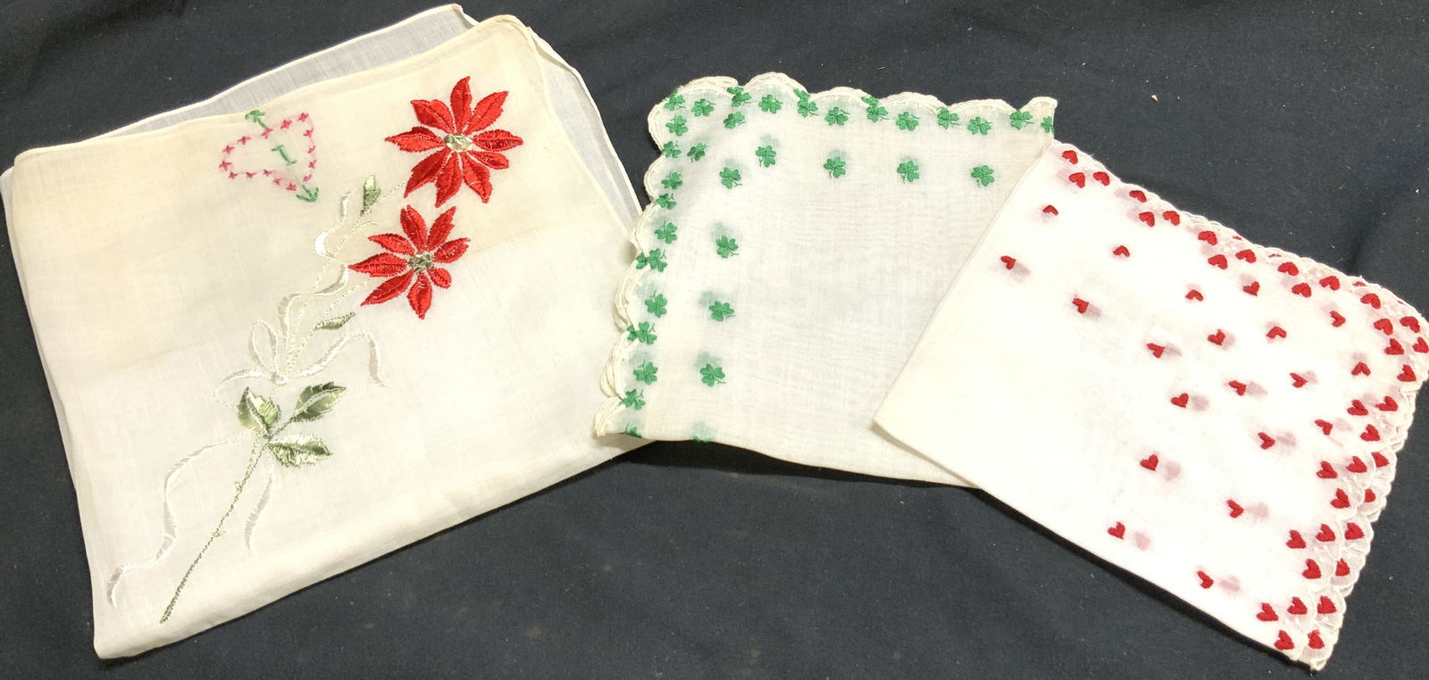 Lot 3 Assorted Embroidered Handkerchiefs: Lot includes 3 handkerchiefs. Each piece is vintage. Includes 1 multi toned floral detailed, 1 with heart pattern detail, & 1 with three leaf clover detail. Each linen is white toned. Largest linen me