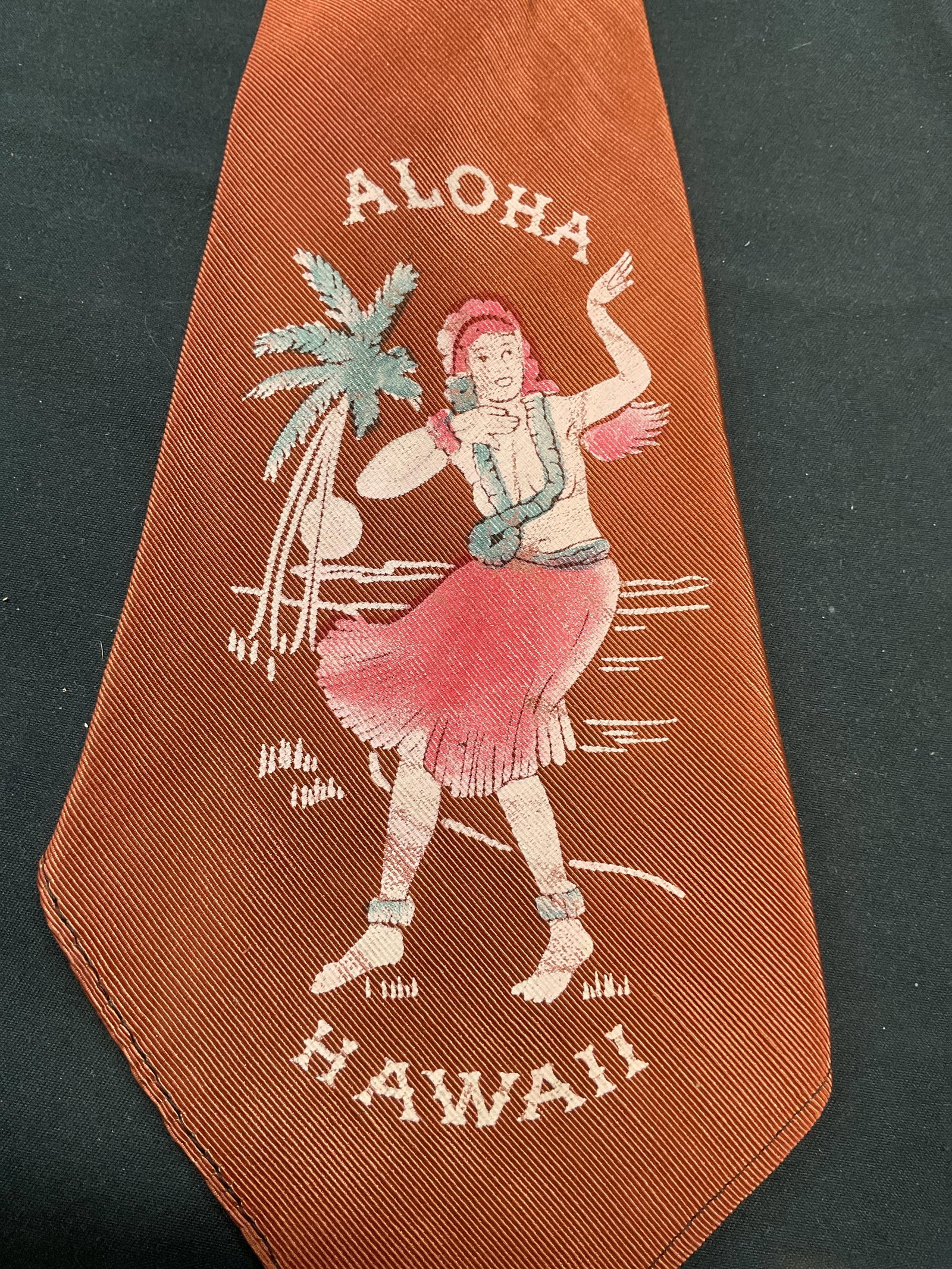 Vintage Aloha Hawaii Hula Dancer Red Tie: Vintage red tie with graphic print. Hula dancer with text that reads Aloha Hawaii. Synthetic material. Measures approx. 45 inches long. Some wear to material including fading and discoloration observe