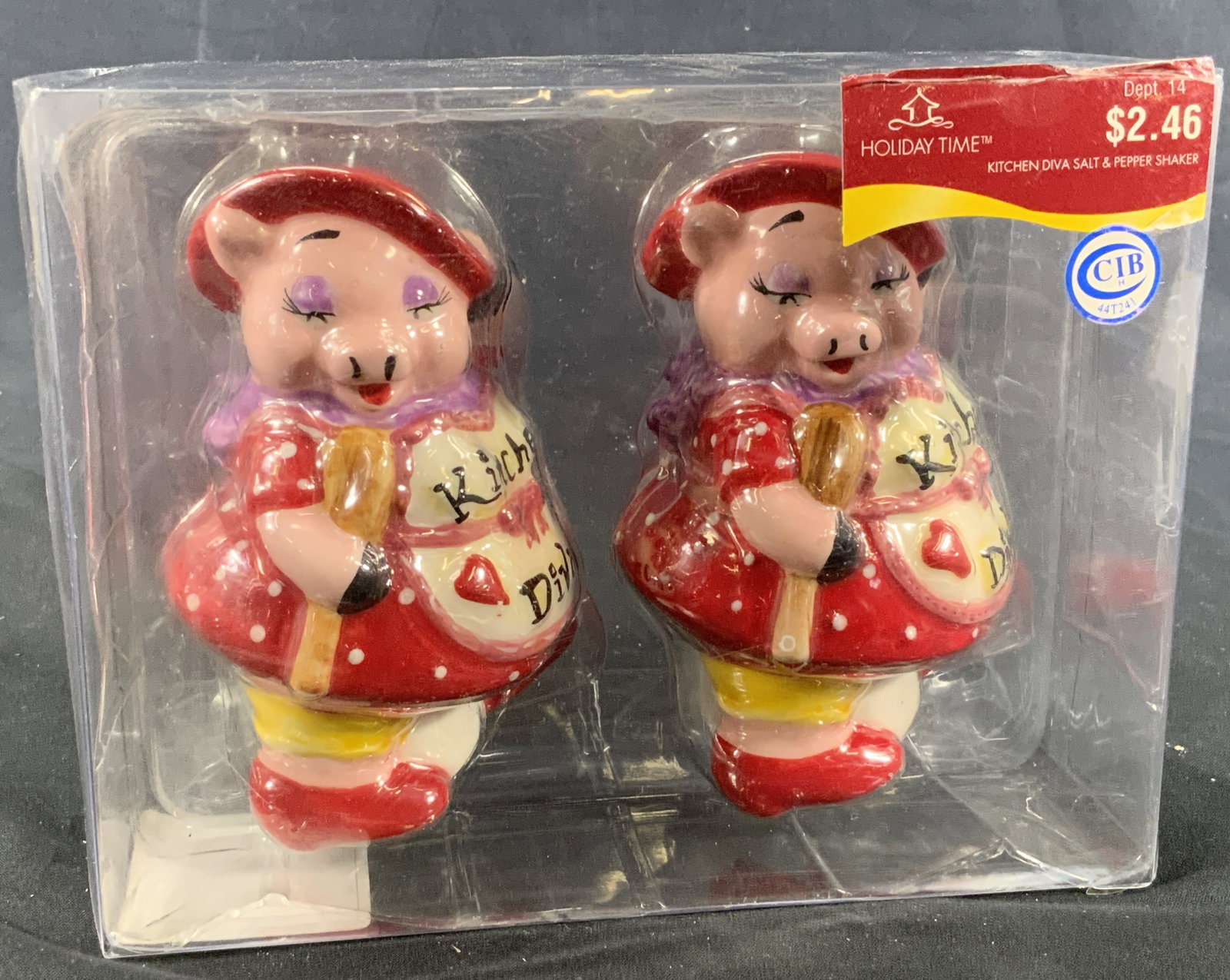 Valentine Piggy Kitchen Diva Salt & Pepper Shakers: Ceramic salt and pepper shakers. Shakers depict two pigs with aprons that read Kitchen Divas. Each have holes on top. Both are packaged in case. Case measures approx. 7 W x 5 H x 3.5 D in. Minor wear 