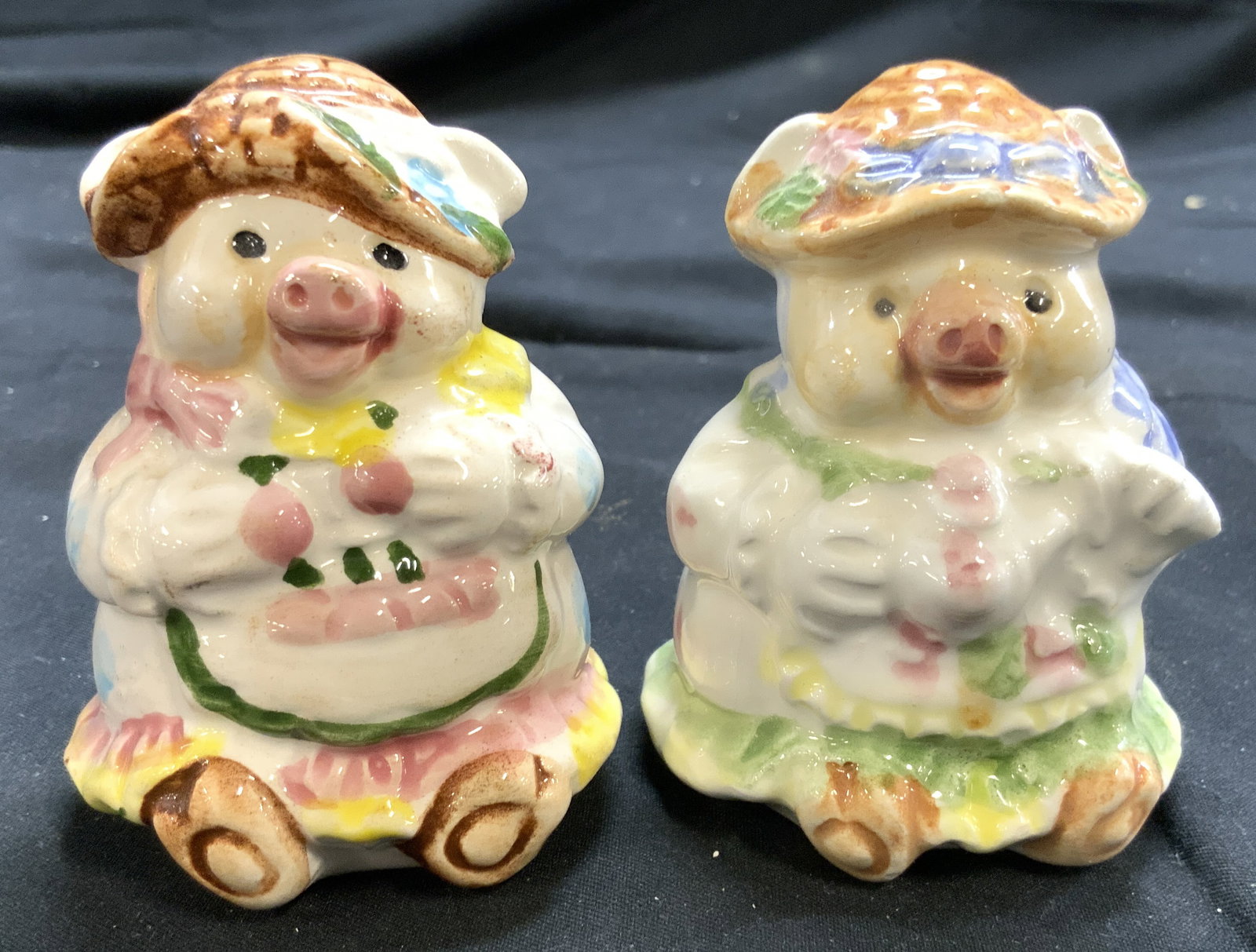 Hand Painted Porc Pig Salt & Pepper Shakers: Lot includes 1 salt and 1 pepper shaker. Each piece is porcelain. Shakers appear to be vintage. Each appear to be hand painted. Depicts pigs wearing dresses and hats. Each measures approx 3 inches tal