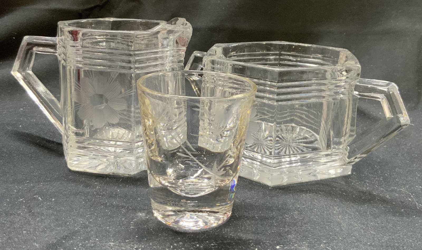 Lot 3 Glass Creamer Dish Sugar Dish & Shot Glass: Lot includes 1 creamer dish, 1 sugar dish & 1 shot glass. Creamer and sugar dishes each have frosted floral detailing. Shot glass has vine and leaf detailing, sugar dish has 2 handles. Piece measures 